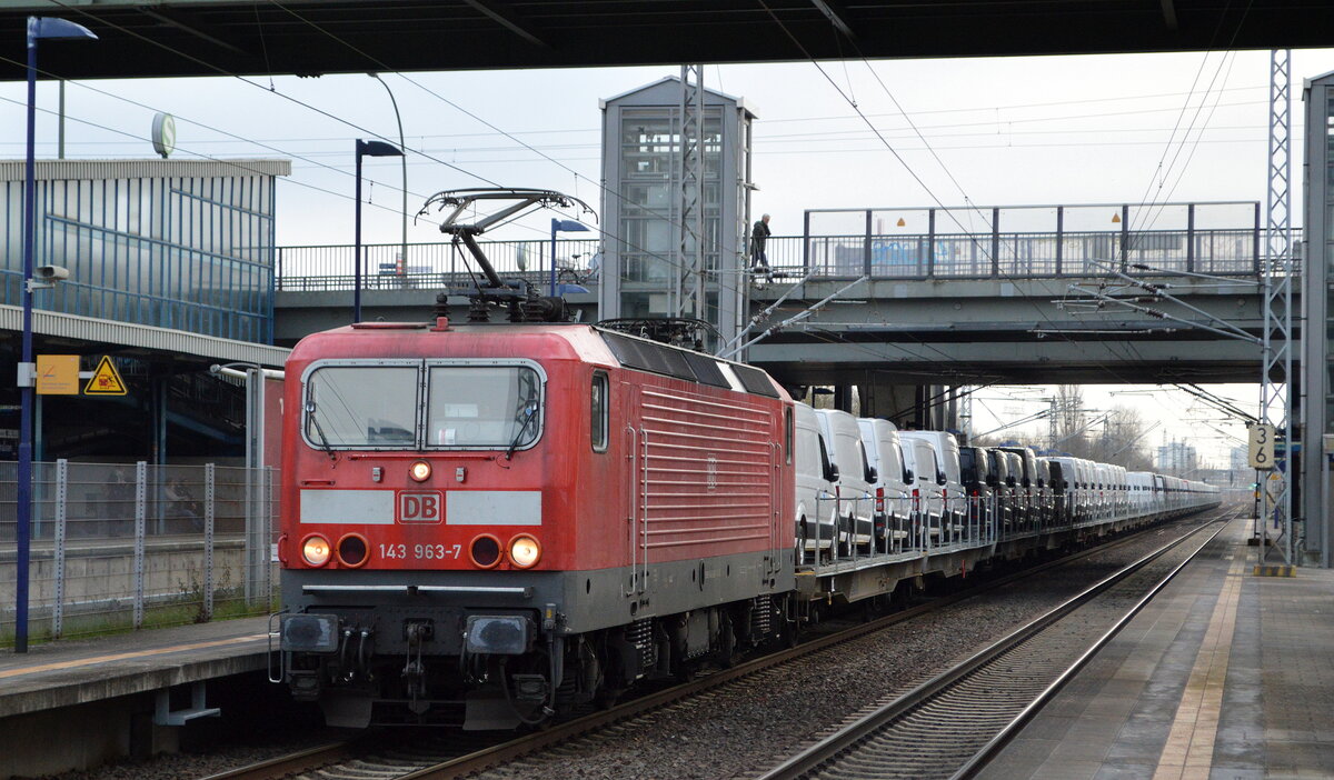 DeltaRail GmbH, Frankfurt (Oder) mit der angemieteten  143 963-7  (NVR-Nummer   91 80 6143 963-7 D-DB ) und Nutzfahrzeug-Transportzug (VW Fahrzeuge aus polnischer Produktion) Richtung Norden am 21.12.21 Durchfahrt BF. Berlin Hohenschönhausen.