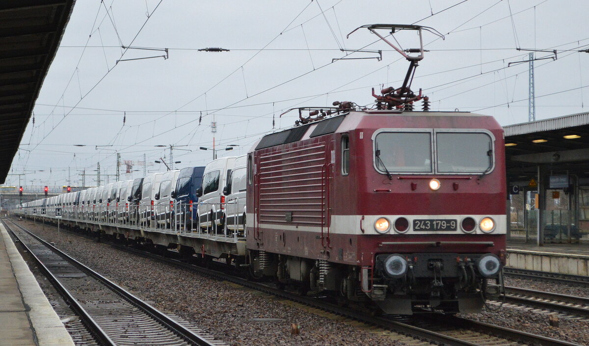 DeltaRail GmbH, Frankfurt (Oder) mit  243 179-9  [NVR-Nummer: 91 80 6143 179-0 D-DELTA] und einem Fahrzeugtransportzug mit fabrikneuen VW-Nutzfahrzeugen aus polnischer Produktion  am 08.02.22 Durchfahrt Bf. Flughafen BER - Terminal 5.