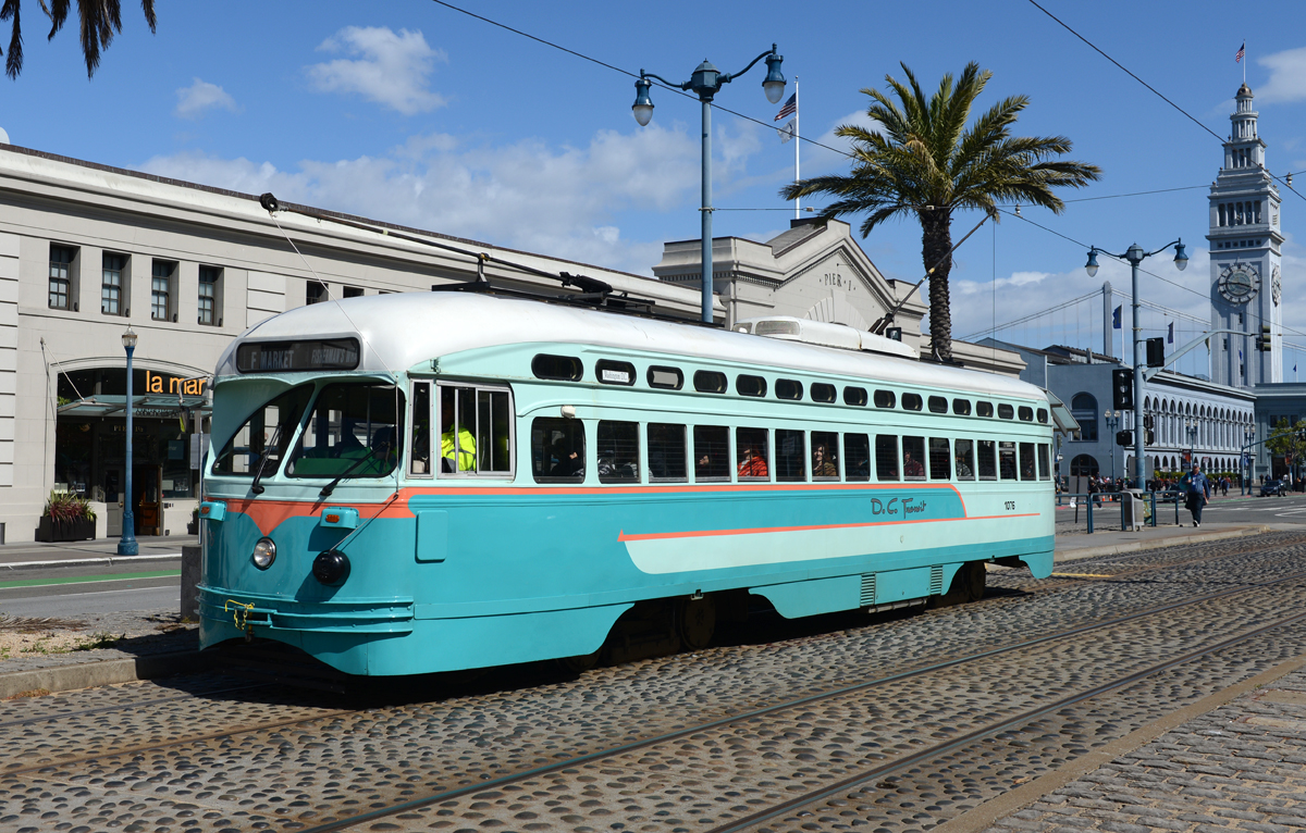 Dem Embarcadero in Richtung Fishermans Wharf fahrend habe ich den PCC Wagen mit der Ordnungsnummer 1067 welcher als Hommage an das 1962 stillgelegte Straßenbahnnetz  D.C. Transit  gestaltet wurde am 27 April. 2016 vor dem Pier I fotografiert, im Hintergrund ist der imposante Uhrturm des Ferry Buildings zu sehen. 