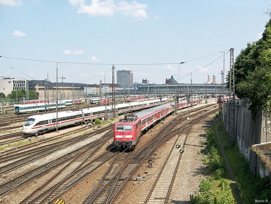 Den Blick schweifen lassen und einfach mal das Bahngeschehen beobachten: Das wurde am 10.7.2013 getan. Während im Vordergrund 111 172 mit einem Regionalzug aus Kufstein einfährt, tummeln sich vor der Münchner Stadtsilhouette alle möglichen weiteren Züge des täglichen Bahnbetriebs am Münchner Hauptbahnhof. Aufgenommen von der Hackerbrücke aus.