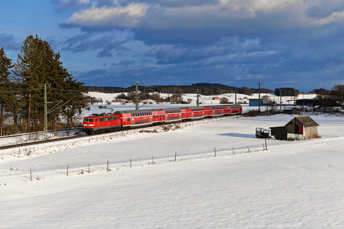 Der 24. Januar 2021 zeigte sich recht wolkig, einige geplante Aufnahmen wurden dadurch zunichte gemacht. Als der von 111 087 geführte RE 57412 nach Memmingen meinen Standpunkt bei Sontheim im Unterallgäu passierte, kam allerdings zum rechten Augenblick die Sonne zum Vorschein. Wer hätte das gedacht, daß die Baureihe 111 einmal bis ins Allgäu hinein eingesetzt wird? Leider dauert diese Episode nur ein Jahr lang, dann übernimmt GoAhead die Leistungen von DB Regio.