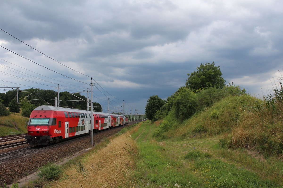 Der 86-33 018 gezogen von 1144 290 fährt am 9.7.2015 als E1626 von Wien West nach St.Valentin hier kurz hinter St.Pölten dem Gewitter entgegen.