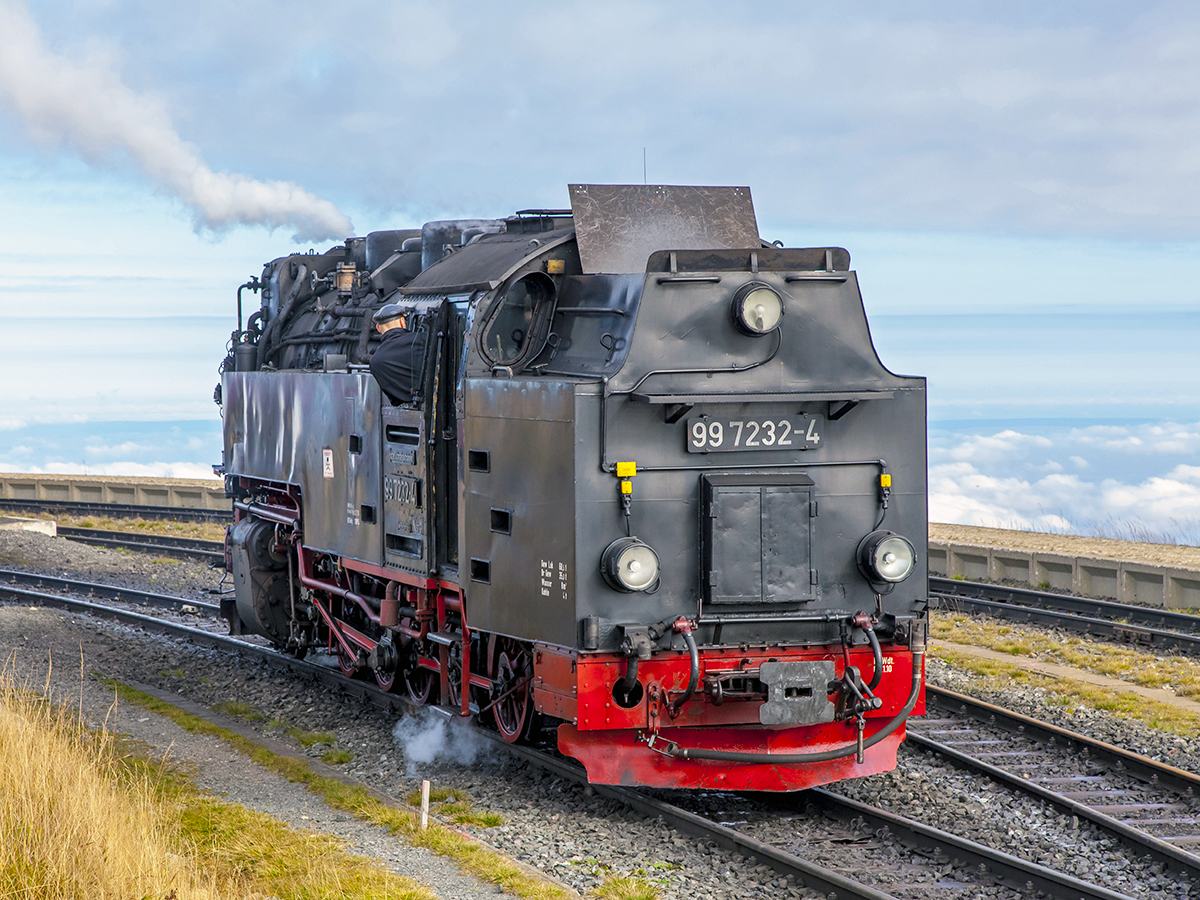 Der 99 7232-4 rangiert im Bahnhof Brocken am 30. September 2015. Die Wolken betonen die Höhe des Bahnhofs unten.