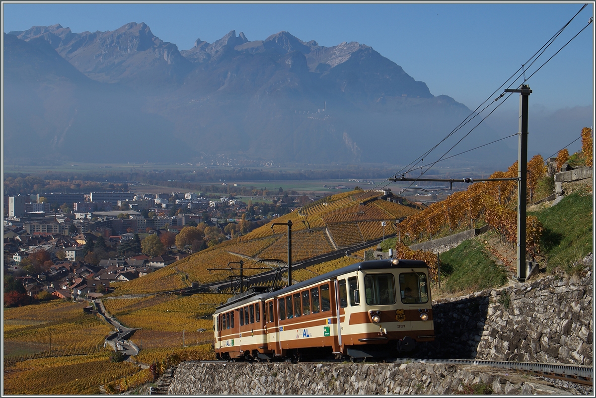 Der A-L Bt 351 mit dem schiebenden A-L BDeh 4/4 302 passt recht gut in die herbstliche Reblandschft oberhalb von Aigle. Der A-L Regionalzug 244 von Aigle nach Leysin erreicht in Kürze Fontanney. 
1. Nov. 2015