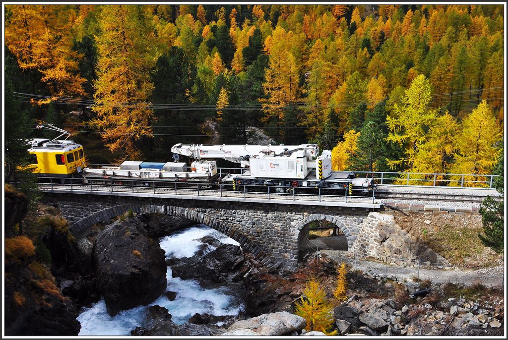 Der ABe 4/4 II 46 und der Diensttriebwagen 23201 überführen den Kirow-Schienenkran der Firma Sersa aus dem Puschlav nach Pontresina. Hier überqueren sie den Ova da Bernina bei Morteratsch. (08.140.2015)