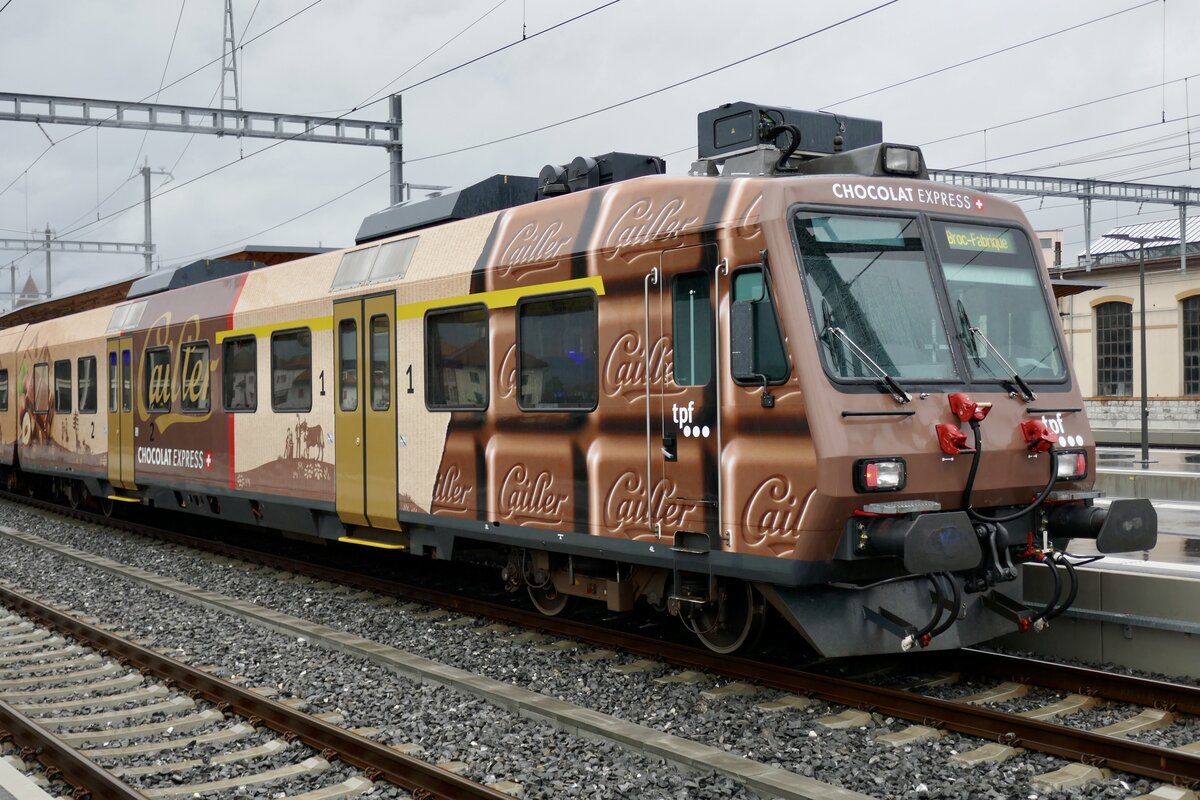 Der ABt 865-7 der TPF mit der  ChocolatExpress  Vollwerbung am 28.8.23 im Bahnhof Bulle.