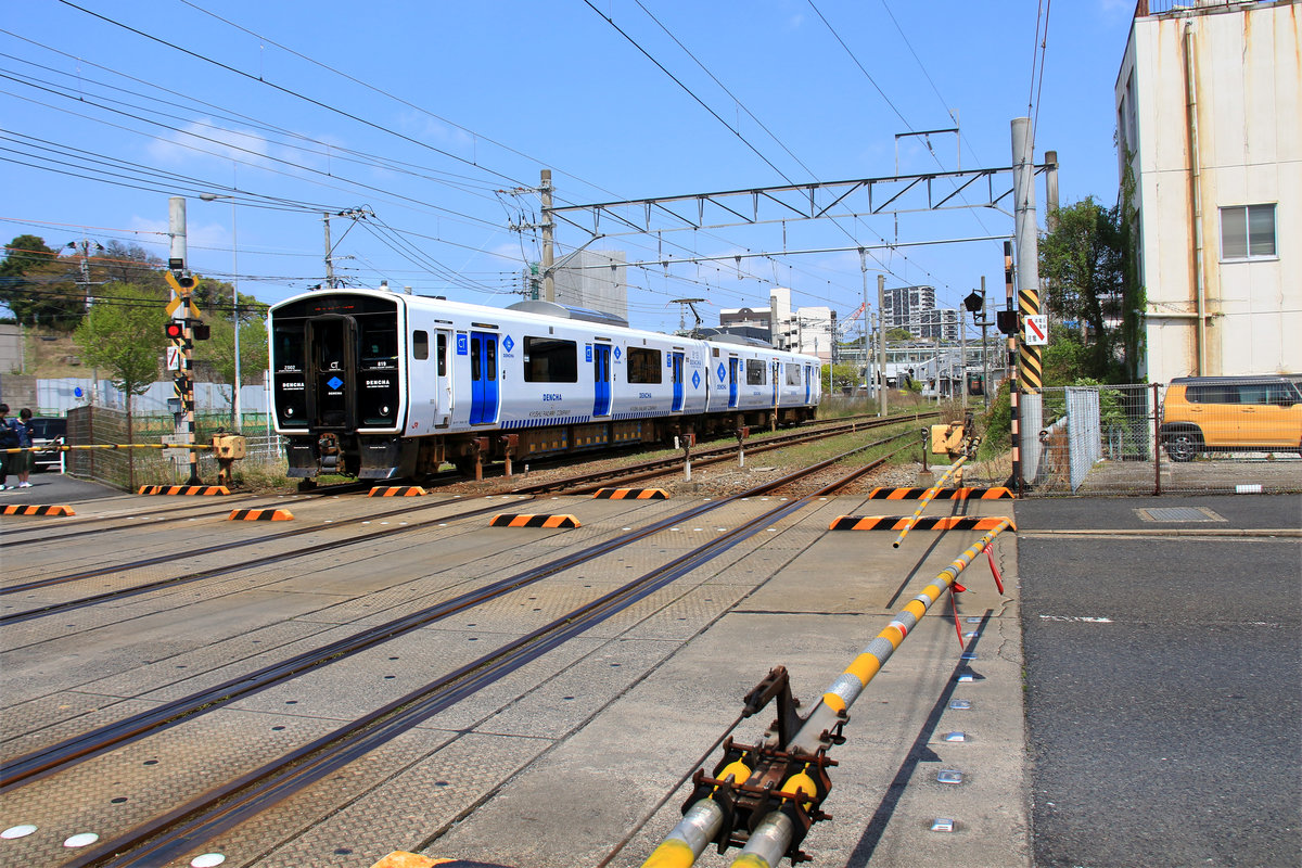Der Akku-Triebzug von JR Kyûshû, Serie BEC 819. Der Zug trägt den Namen  Dencha (Dentscha) ; das ist ein Spiel auf das Wort  Densha  (das allgemeine Wort für  Zug  im Japanischen, eigentlich  elektrischer (den) Zug (sha) .)  Dencha  ist abgeleitet von den englischen Wörtern  Dual Energy Charge Train . Die BEC 819 fahren mit gehobenem Stromabnehmer unter Wechselstrom 20 kV/60 Hz, und mit gesenktem Stromabnehmer mit Batterie Gleichstrom 1600 V. Es gibt 7 Züge, die 2016 in Dienst kamen, und 11 Züge, die 2019 in Dienst kamen. Im Bild Zug BEC 819 Nr. 2 in Orio, Nord-Kyûshû, mit gehobenem Stromabnehmer. 8.April 2018 