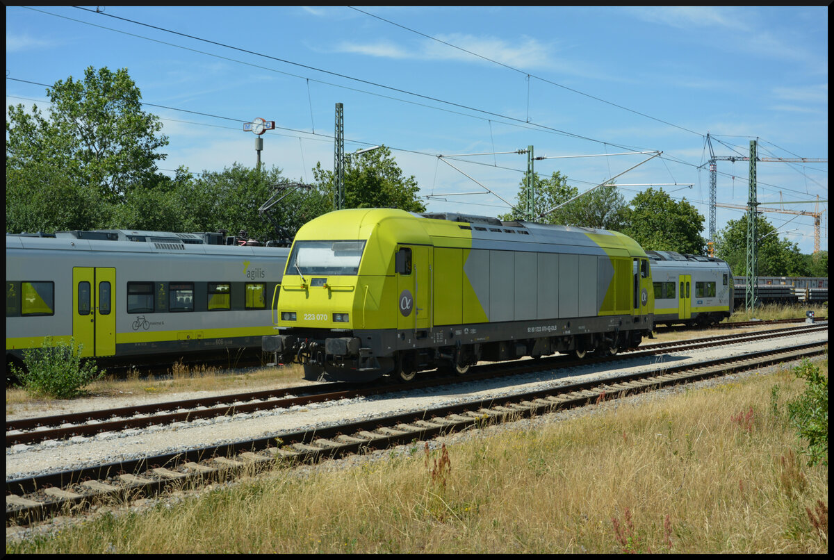 Der Alpha Trains Eurorunner ER20 (223 070-4) wartet am 15.07.2023 in Neumarkt in der Oberpfalz neben einem farblich passenden Agilis-Triebwagen auf neue Aufgaben.
