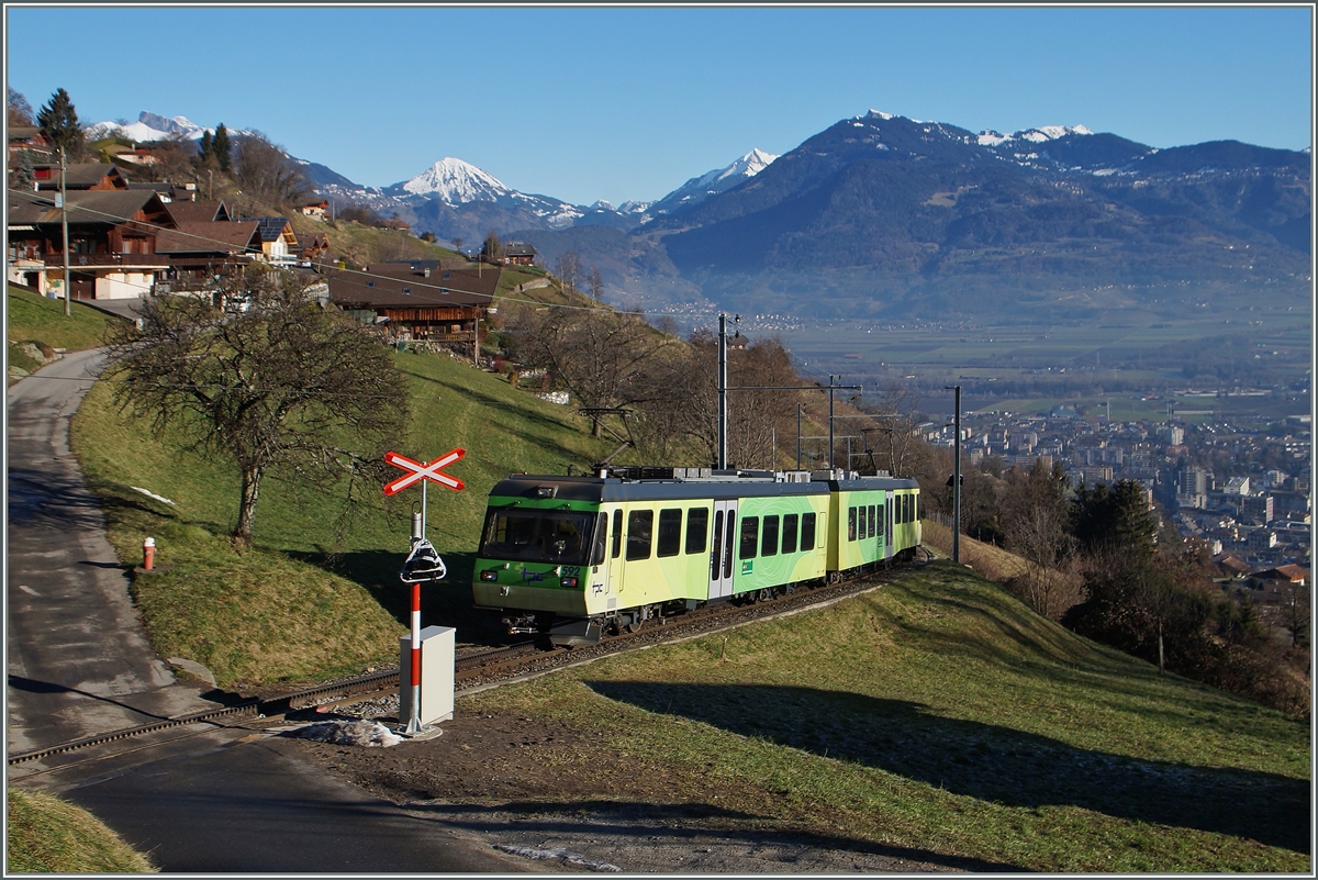 Der AOMC Beh 4/8 592, unterwegs als Regioanlzug 29 von Champéry nach Aigle erreicht hat die die Haltestelle  Pont de Chemex  verlassen und fährt nun talwärts Richtung Monthey-Ville.  7. Januar 2015