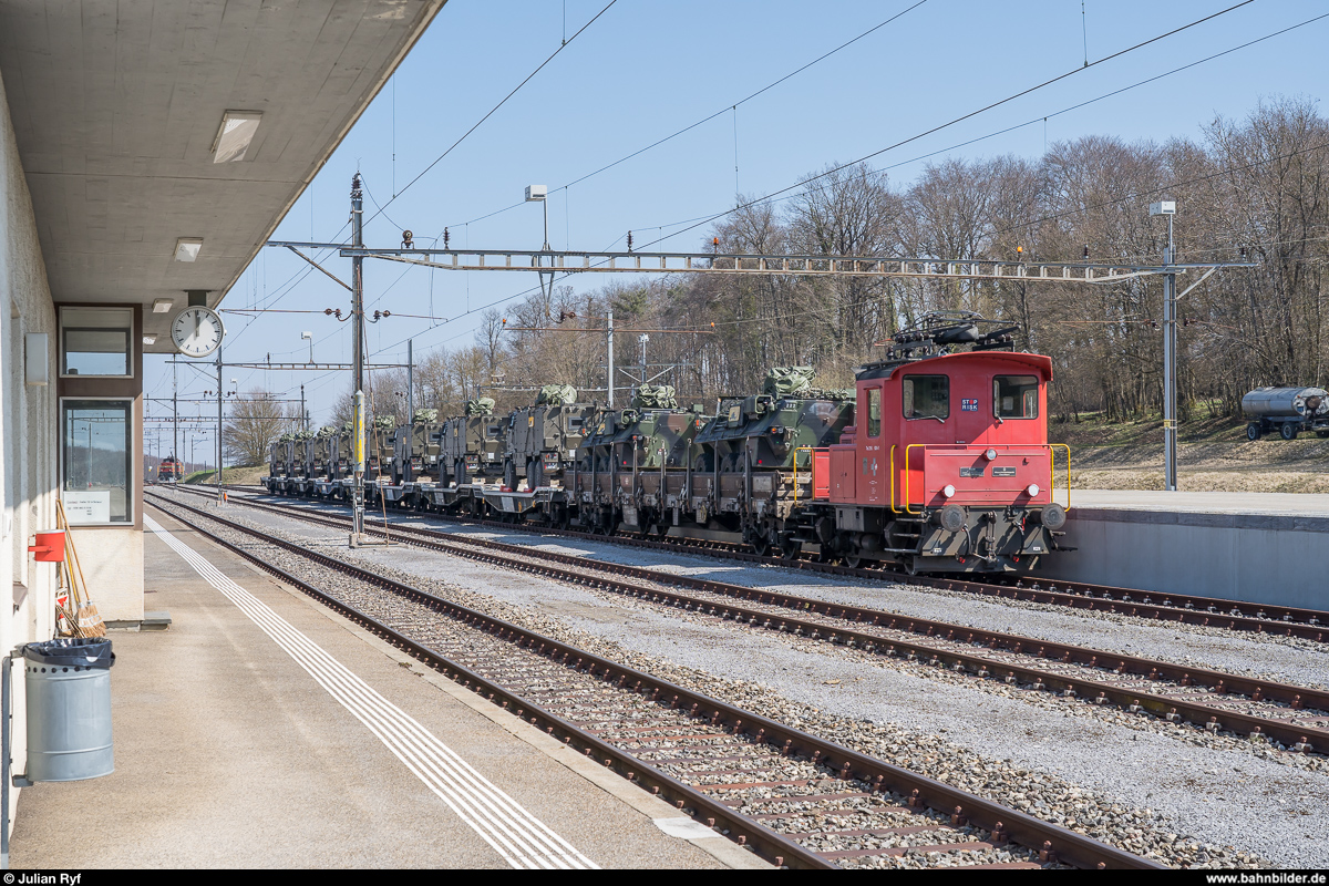 Der Armee-eigene Te 216 924 steht am 29. März 2019 mit einer Reihe mit Panzerfahrzeugen beladenen Flachwagen an der Rampe des ausschliesslich Militärtransporten dienenden Bahnhofs Bure.