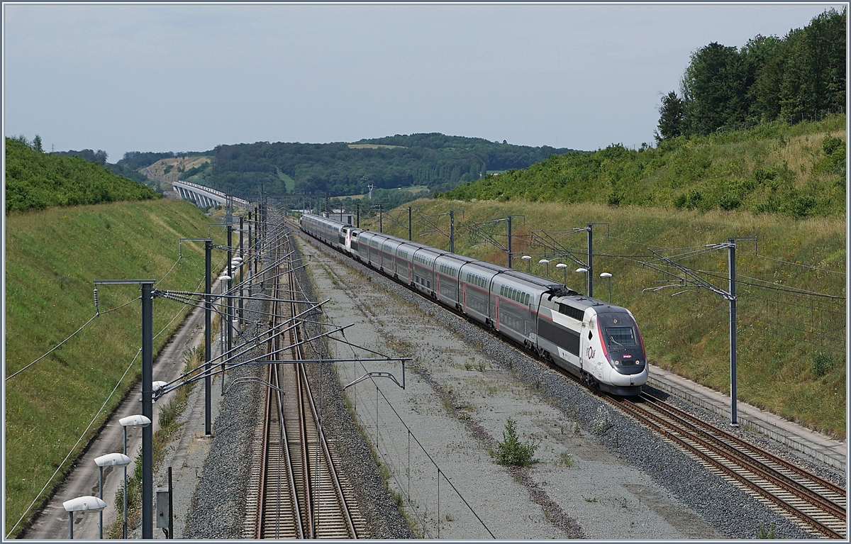 Der aus den Triebzügen 4709 und 4710 bestehende TGV 9582 von Marseille St-Charles nach Frankfurt Main Hbf erreicht den Bahnhof Belfort Montbéliard TGV. Im Hintergrund ist die mit 816 Meter längste Brücke der TGV Linie Rhin-Rhône, das Viaduc de la Savoureuse, zu erkennen. 

6. Juli 2019
