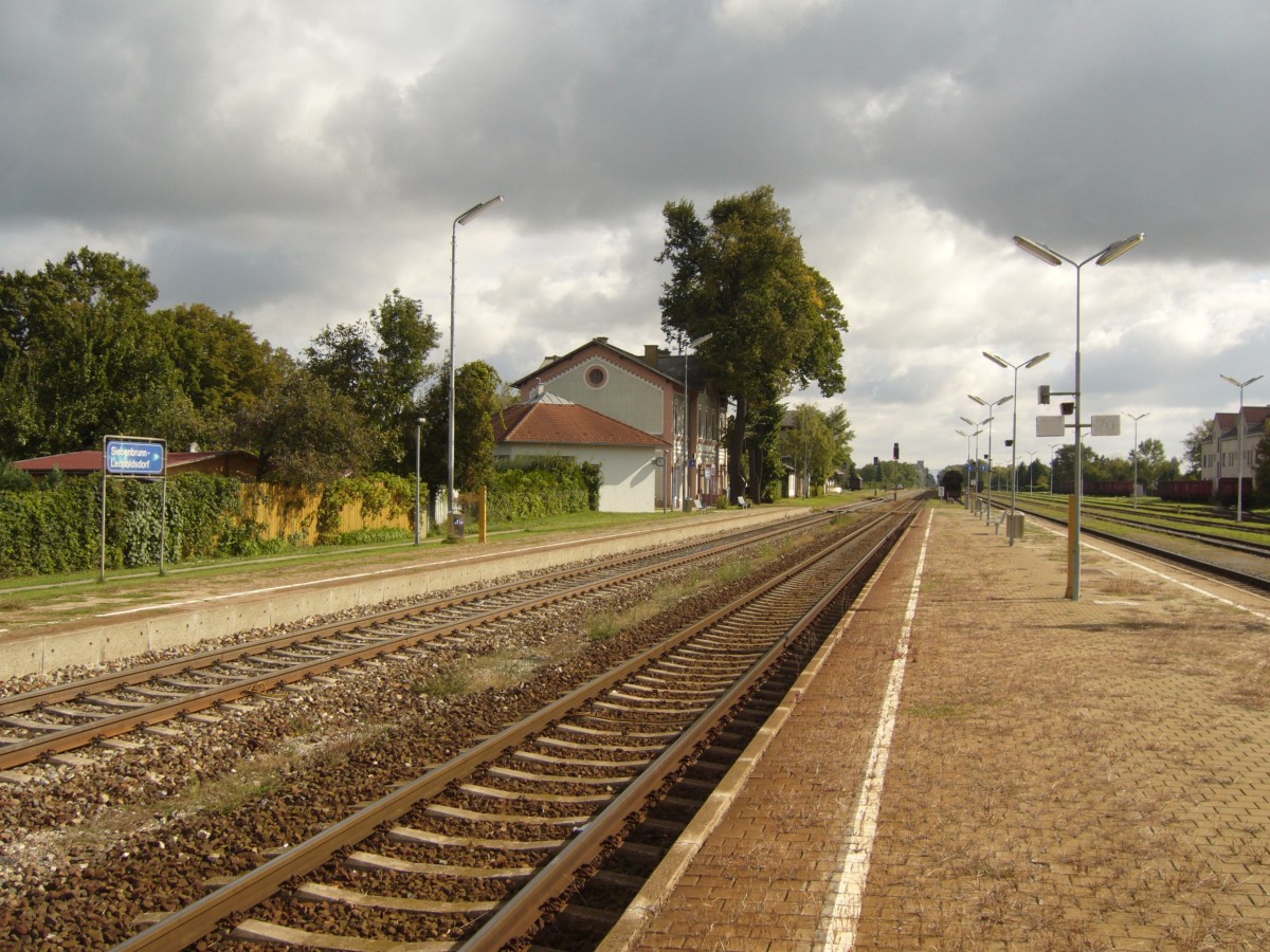 Der Ausgangspunkt der Lokalbahn Siebenbrunn-Engelhartstetten ist der Bahnhof Siebenbrunn-Leopoldsdorf, der an der Marchegger Ostbahn liegt hier mit Blickrichtung Marchegg, besonders markant  finde ich die groen Bume direkt beim Bahnhofsgebude, die dem Bahnhof einen gewissen Flair geben, Sept.2010