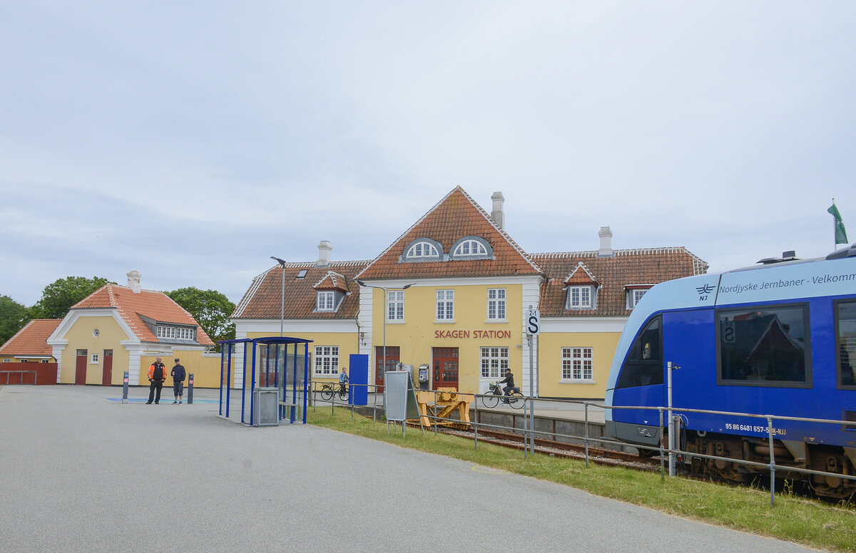 Der Bahnhof Skagen ist der Endbahnhof der Skagensbahn zwischen Skagen und Frederikshavn und ist der n�rdlichste Bahnhof in D�nemark. Der Bahnhof wurde 1890 er�ffnet, als die Skagensbahn zwischen Skagen und Frederikshavn gebaut wurde. Das heutige Bahnhofsgeb�ude wurde 1919 eingeweiht. Der Bahnhof wird heute von Z�gen des Eisenbahnunternehmens Nordjyske Jernbaner bedient, das h�ufige Regionalz�ge zwischen Skagen und Frederikshavn betreibt, mit Anschluss weiter in Richtung Aalborg.
Aufnahme: 12. Juni 2026.