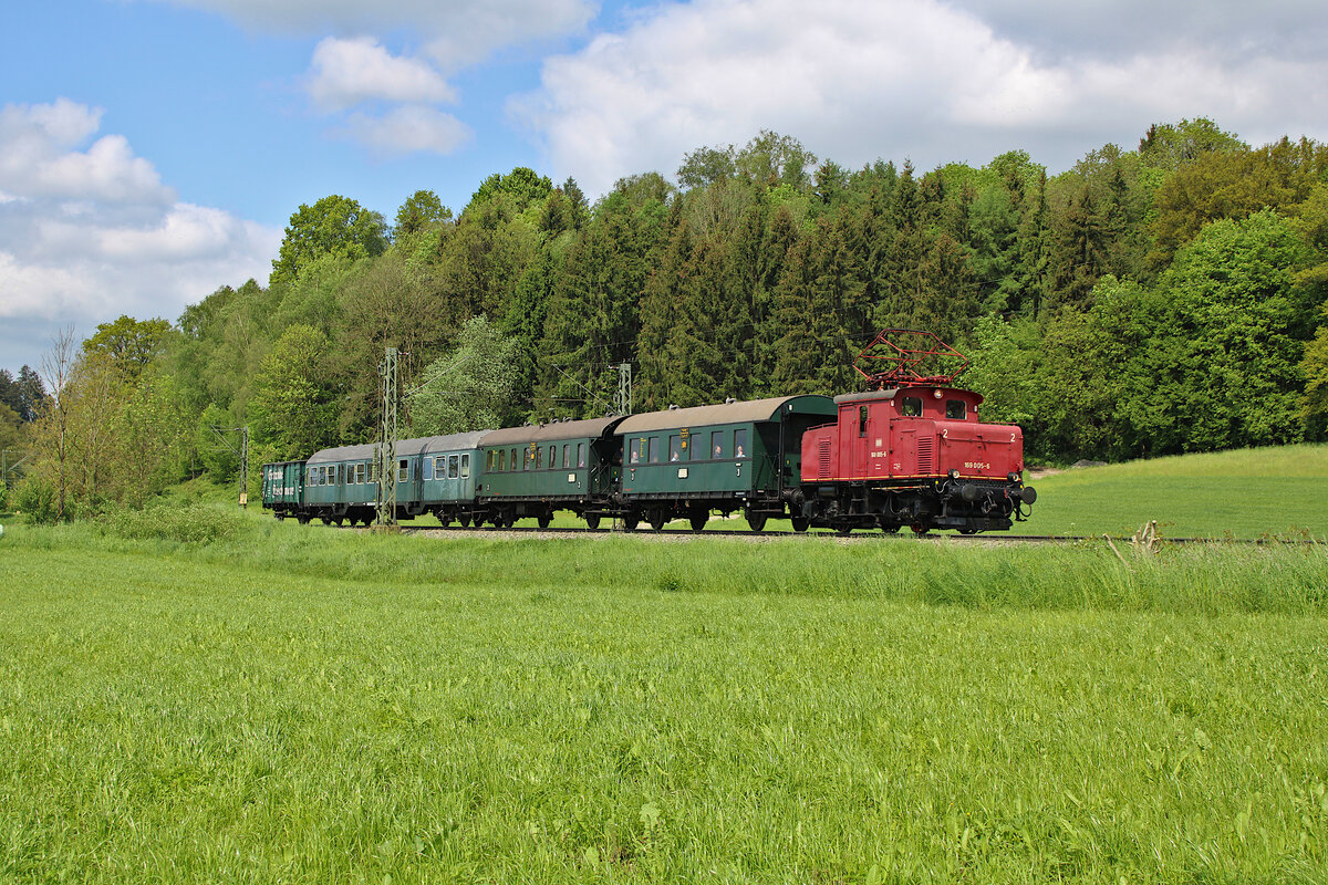 Der Bayerische Localbahn Verein ist mit E69 005 und einem Sonderzug unterwegs von München Ost nach Prien am Chiemsee und fährt hier gerade zwischen Bad Endorf und Prien am Chiemsee. (18.05.2023)