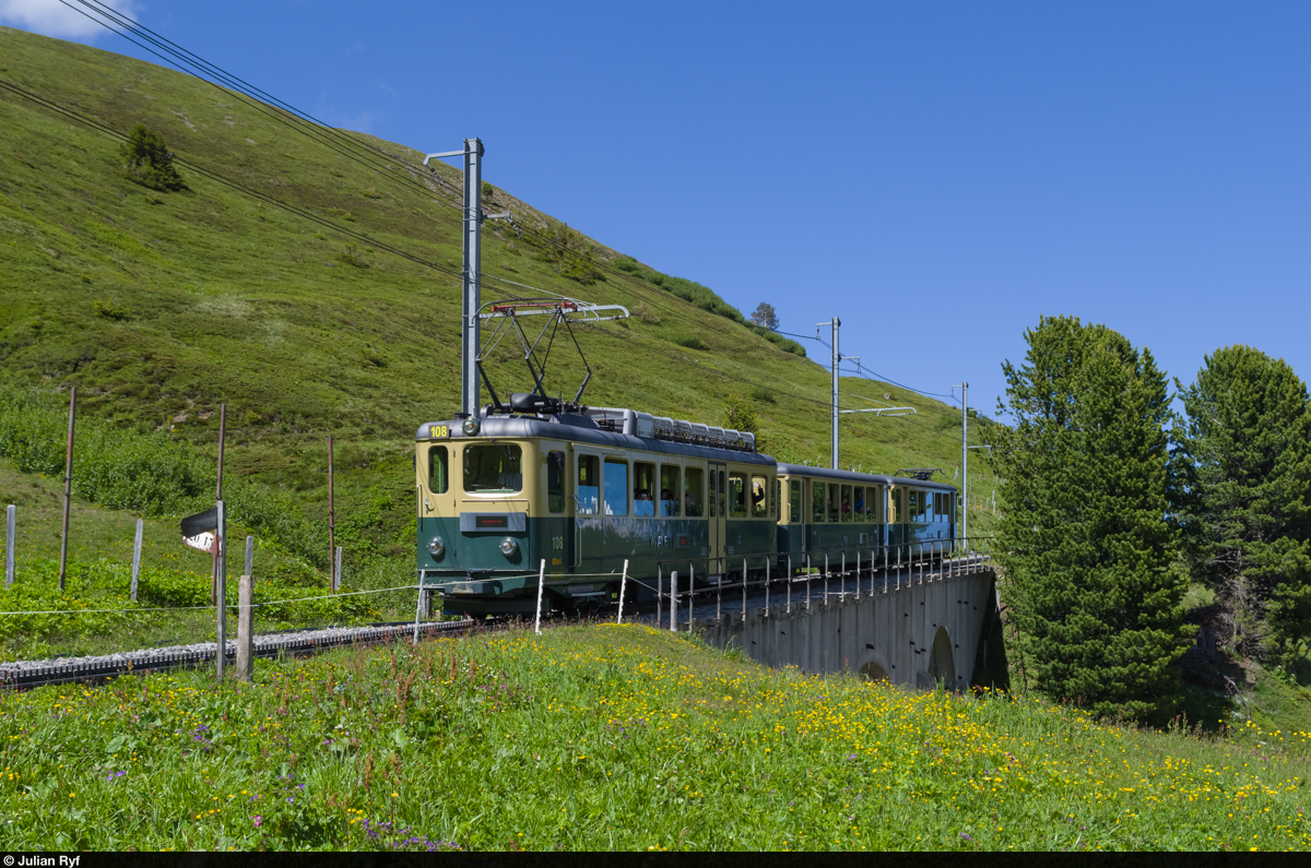 Der BDhe 4/4 108 der WAB fährt am 24. Juni 2015 mit einem Zug in der Sommerkomposition, also mit zwei Personenwagen unterhalb der Kleinen Scheidegg talwärts in Richtung Wengen-Lauterbrunnen.