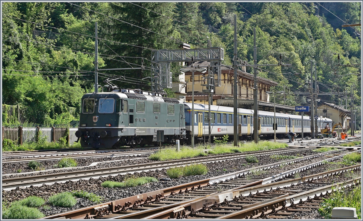 Der bereits erwähnte, das Fotografieren fast verunmöglichte Zaun endet bei der DKW am Ende des Gleis 5 und erlaubt so von Masten eingeschränkt immerhin etwas freizügige Fotografie, wie zu Beispiel der von der Re 4/4 II 11161 geschobene IR 3218 bei der Ankunft in Iselle. 
Das Bild zeigt auch, dass die Idee, vom Zwischenbahnsteig aus (Geis 2/3) rasch vom Tisch war, denn erstens ist der Bahnsteig zu kurz und zweitens wird er gerade renoviert 

Der Zug besteht aus folgenden Reisezugwagen: A 50 85 18 35 028-1, B 5085 20 35 265-1, B 50 85 20 316-2 und dem BDt 50 85 82 33 923-2. 

19. August 2020

