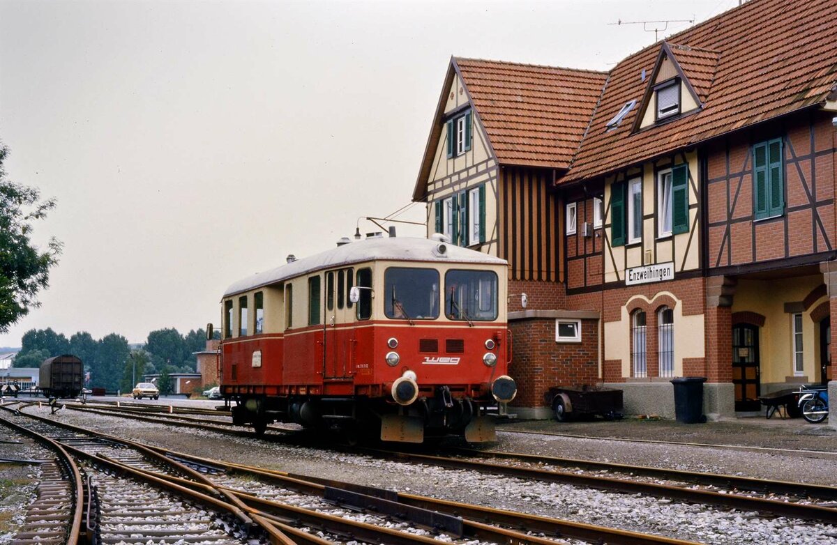 Der berühmte T 04 (Hersteller: Wegmann und MAN) der WEG, einer der ältesten zu dieser Zeit noch eingesetzten deutschen Schienenbusse überhaupt, wartet vor dem Bahnhof Enzweihingen auf seine wenigen Fahrgäste. Früher war er bei der Deutschen Bundesbahn (DB) eingesetzt.
1954 übernahm ihn die WEG und baute ihn umfangreich um. Er wurde auf diese Weise zu einem Schlepptriebwagen.
Datum: 06.09.1984
