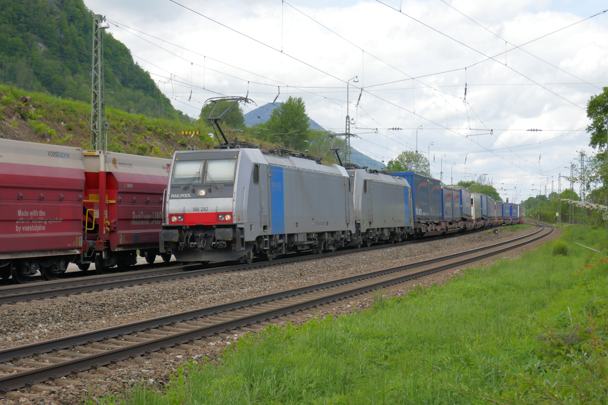 Der Betriebsbahnhof Fischbach am 28. Mai 2021: Links stehen 20  Rocktainer  auf dem Ladegleis des Steinbruchs Fischbach. In der Bildmitte sind 186 286 und 186 283 von Railpool mit einem Zug des kombinierten Ladungsverkehrs unterwegs nach Kufstein und weiter nach Italien.