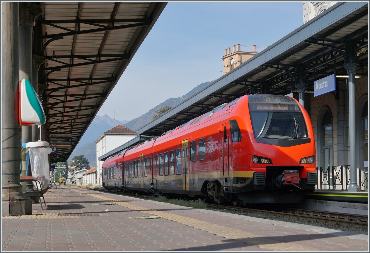 Der bimodulare FS Trenitalia BUM BTR 813 003 wartet in Aosta auf die Abfahrt als Regionale 2722 nach Torino Porta Nuova. Der Zug kann mit Dieselmotoren oder elektrisch mit 3000 Volt Gleichstrom betreiben werden, verfügt für die Achsanordnung Bo' 2'2'2' Bo' und die UIC Bezeichnung (des Antriebsmodul) lautet 90 83 1813 012-1 I-TI. 

27. September 2021 
