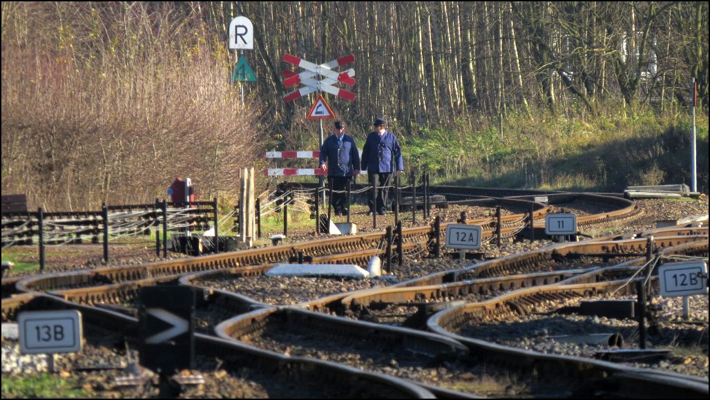 Der Blick auf die Gleisanlagen in Simpelveld vom Bahnsteigsende aus gesehen. Das Bahnpersonal der ZLSM macht sich gerade auf den Weg zum Stellwerk.
szenario vom 14.Dez.2014.