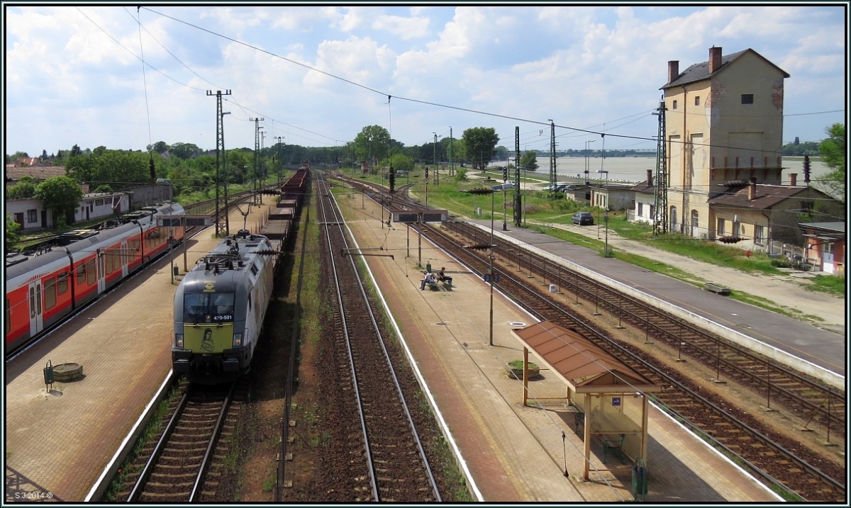 Der Blick zur Westflanke auf den Bahnhof von Komárom. Die 470 501 fährt gerade mit einen gemischten Güterzug in Richtung Budapest.Rechts im Bild ,die Donau.Sie teilt die Stadt ,da genau in der Mitte die Grenze verläuft. Komárom/Komarno Ungarn/Slovakei. Szenario vom 21.Mai 2014.