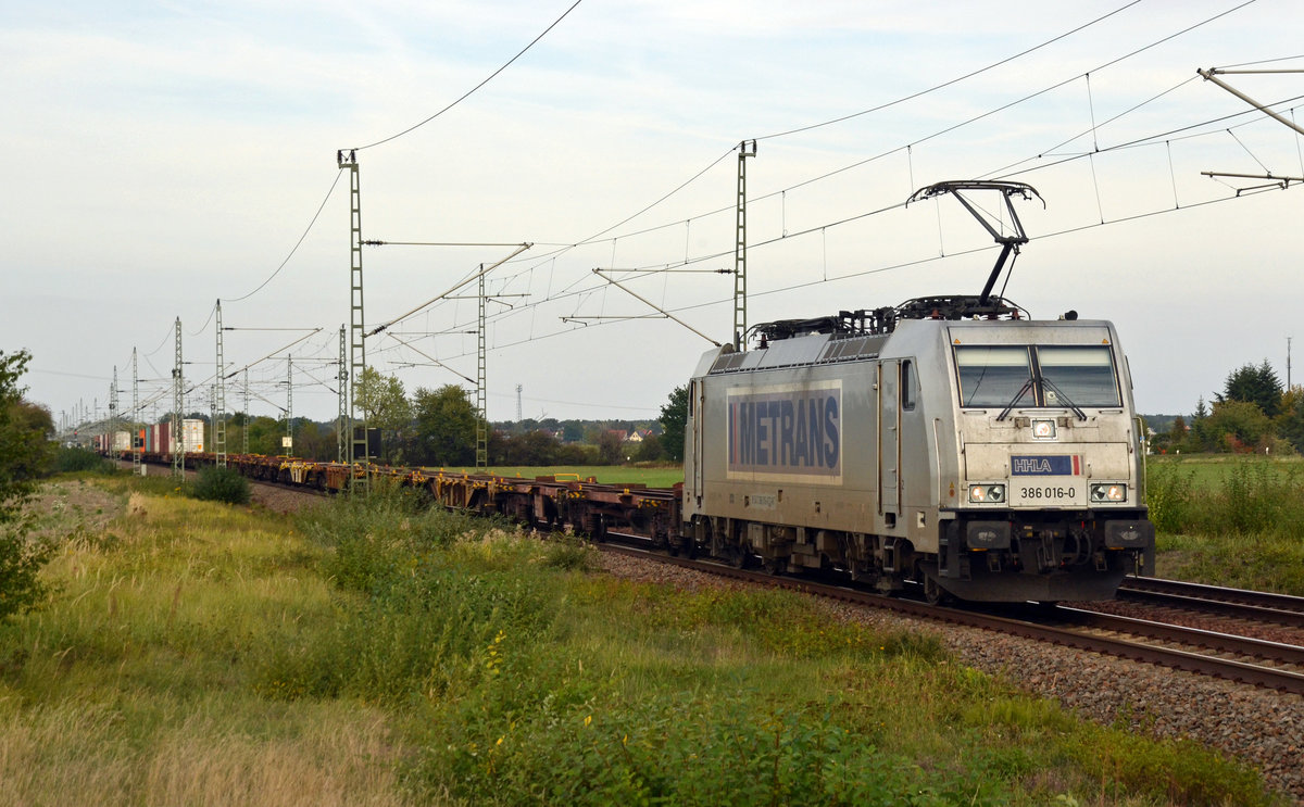Der Containerzug von 386 016 war am 23.09.19 im vorderen Teil unbeladen und gab dadurch den Blick frei auf den Ort Radis. Hier rollt die Metrans-Lok mit ihrem Zug durch Gräfenhainichen Richtung Bitterfeld. 