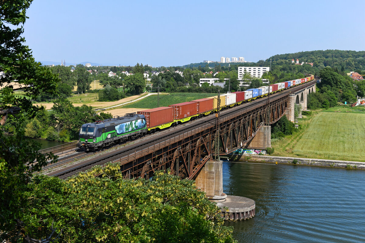 Der Containerzug DGS 42944 von Enns nach Weddewarder Tief fährt an Sonntagen sehr verläßlich und passiert am Nachmittag Regensburg. Am 19. Juni 2022 war er mit der für die WLC fahrenden 193 213 bespannt, die mit ihrer Gestaltung auf die Umweltfreundlichkeit des Schienengüterverkehrs hinweist. 