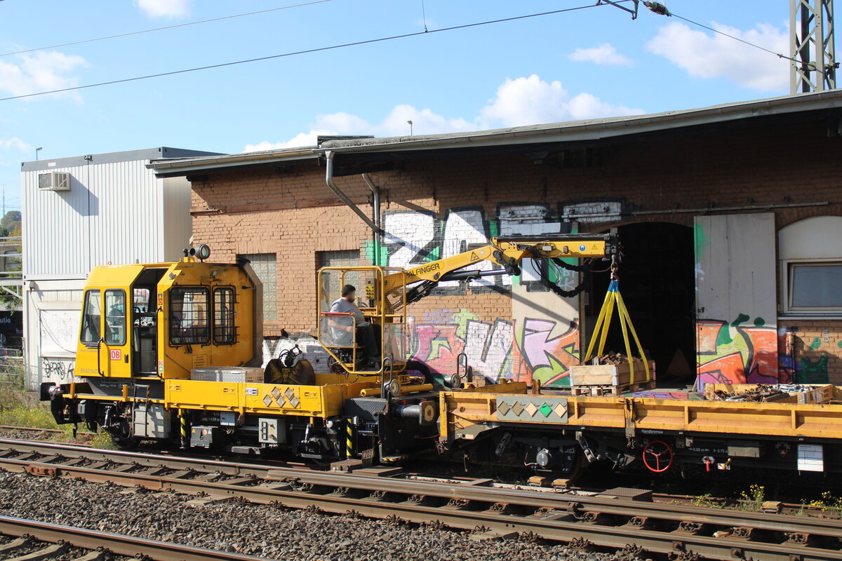 Der DB Netz Instandhaltung GAF 741 xxx hat am 12.10.2026 am G�terschuppen in Bielefeld Hbf mit dem Palfingerkran eine Kiste mit Kleineisen auf den Gleiskraftwagenanh�nger 99 80 9750 315-0 D-DBMP verladen.