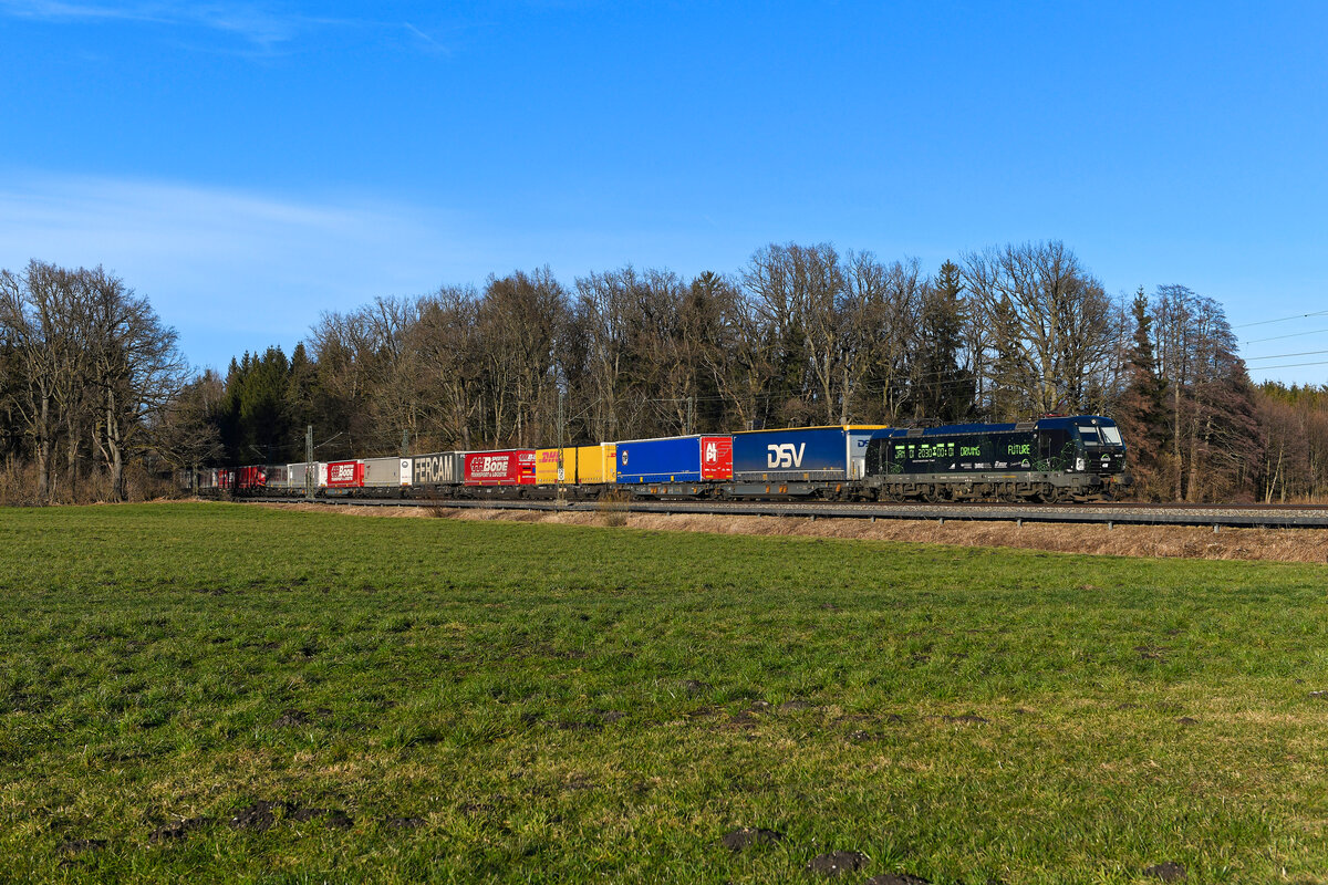 Der DGS 43143 wurde am 03. Februar 2024 auf seiner Fahrt von Lübeck-Skandinavienkai nach Verona Q.E. in Italien von der 193 212 bespannt. Der für TXL im Einsatz stehende Vectron trug zum Aufnahmezeitpunkt erst seit wenigen Tagen eine neue äußere Gestaltung. Das Design, ganz in Schwarz mit grüner Schrift, basiert auf einer Digitaluhr mit dem festen Datum 1. Januar 2030, 00:00 Uhr und eine Minute. Die Botschaft lautet wie folgt: Bis dahin ist noch Zeit, geeignete Maßnahmen zu ergreifen, um deutlich mehr Güter auf den klimafreundlichen Schienenverkehr zu verlagern und die Klimaschutzziele im Verkehrssektor pünktlich zu erreichen. Bei Brannenburg im Inntal konnte ich die Lokomotive am Nachmittagen des besagten Tages dokumentieren. 