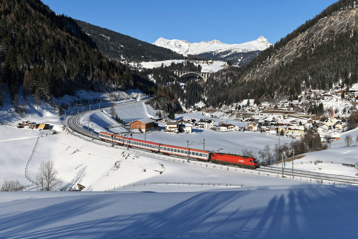 Der diesjährige Winter scheint aufgrund der globalen Erwärmung in tieferen Lagen komplett schneefrei zu bleiben. Um wenigstens ein paar Bilder mit der von mir schmerzlich vermissten weißen Pracht anzufertigen, besuchte ich am 08. Februar 2020 die Brennerbahn. Dort hatte es wenige Tage zuvor kräftig geschneit. Der Blick auf Sankt Jodok ist auf den relevanten Plattformen schon unzählige Male vertreten, dennoch fotografiere ich dort nach wie vor gerne. Der Tag begann für mich mit einer Aufnahme des REX 1826 von Trento nach Innsbruck, der an diesem Tage von der 1216.021 gezogen wurde. 