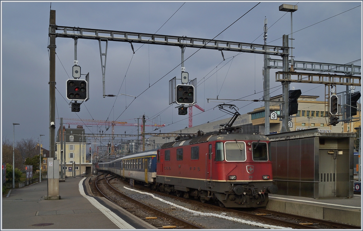 Der Dispozug verlässt in der Fahrlage des IR90 1710 mit der SBB Re 4/4 II 11194 an der Spitze und der dies Bild bestimmenden  Re 4/4 II 11197 den Bahnhof von Lausanne in Richtung Genève. 

25. Jan. 2020