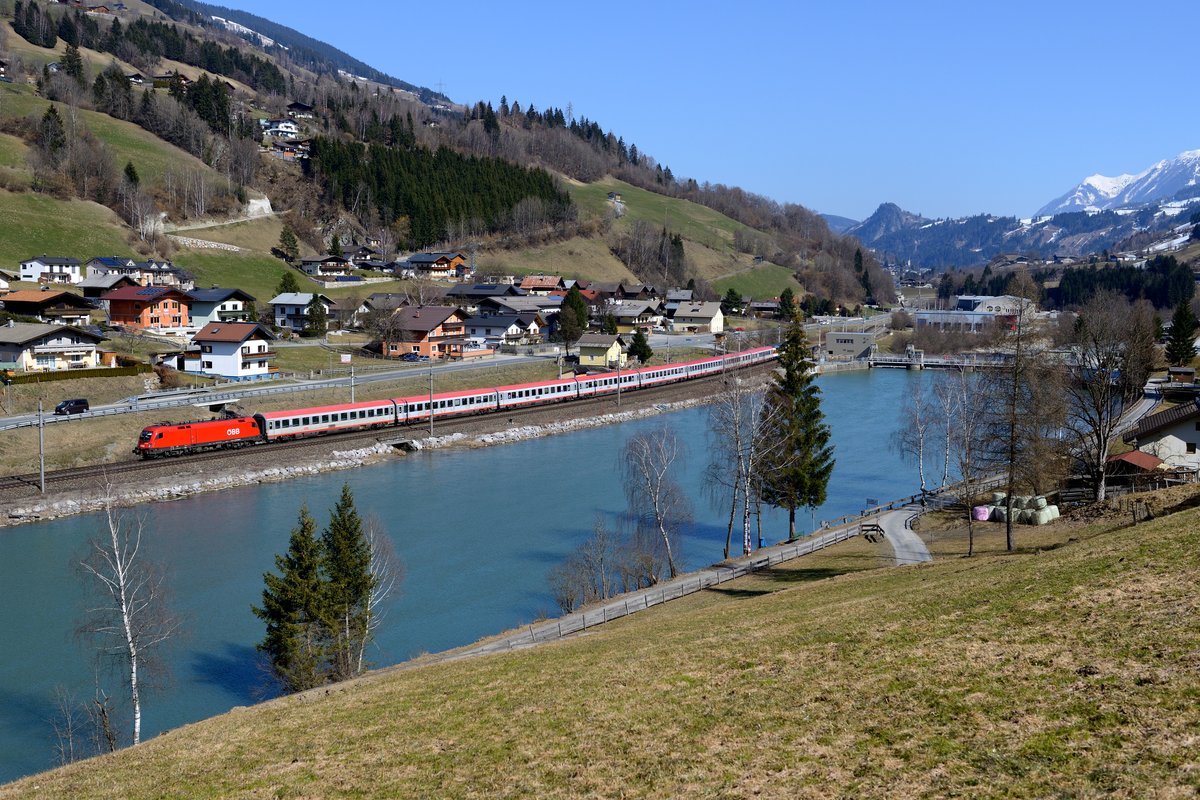 Der EC 164 von Graz HBF nach Zürich HB trägt zumindest in der Schweiz noch den traditionsbeladenen Namen  Transalpin . Am 20. März 2016 konnte ich diesen Fernzug, geführt von 1116.054, bei Högmoos am gestauten Salzachufer aufnehmen.