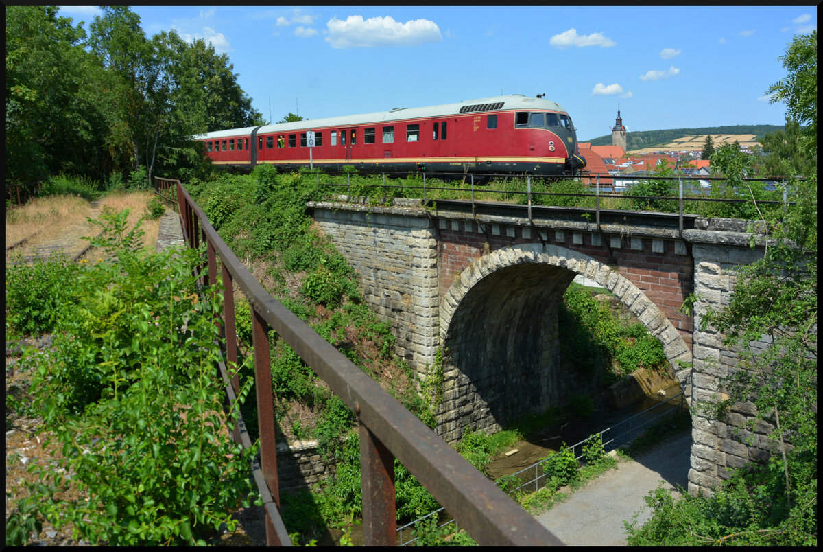 Der  Eierkopf  -  Stuttgarter Rössle  (VT 12 506/507) am 09.07.2023 vor der Kulisse Tauberbischofsheims. Das Geländer im Vordergrund gehört zur Brehmbach-Brücke der längst stillgelegten Bahnstrecke nach Königheim. 