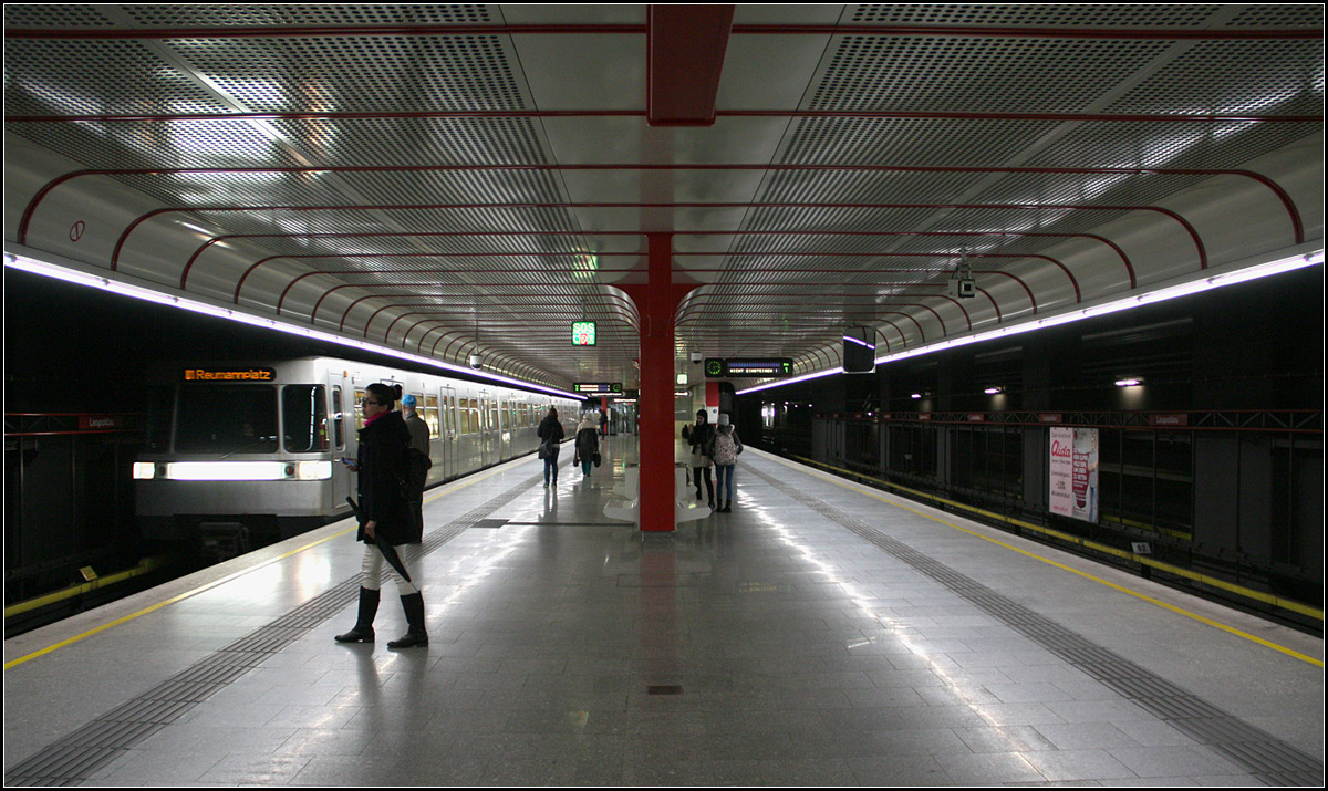 Der Eindruck täuscht in doppelter Hinsicht -

Obwohl es so aussieht, als würde man sich hier unter der Erde befinden, handelt es sich hier doch um eine ebenerdige Station, die komplett eingehaust wurde und mit einem Parkhaus überbaut wurde. Die Zugänge kommen von unten. Die nördliche Endstation der Linie U1 Leopoldau liegt parallel zur dortigen Bahnstrecke.

Auch kann man sich täuschen, was die Entstehungszeit des Bahnhofe angeht. Obwohl die nördliche Verlängerung der U1 erst 2006 in Betrieb ging, also 28 Jahre nach dem ersten Abschnitt dieser Linie, wurde die ursprüngliche Architektur von damals auch für diese neuen Bahnhöfe übernommen. Auch die noch in Bau befindliche Südverlängerung der U1 wird diese Gestaltung bekommen. Die U1 hat dann bis auf den U-Bahnhof Karlsplatz ein einheitliches Erscheinungsbild, egal wie alt die Stationen sind. Das ist selten bei U-Bahnen.

Die Architektengruppe U-Bahn gestaltete auch die Bahnhöfe der U3 und U6-Nord. Dort wurde auf die Abrundungen und die farbigen Abdeckungen zwischen den Verkleidungen verzichtet.

