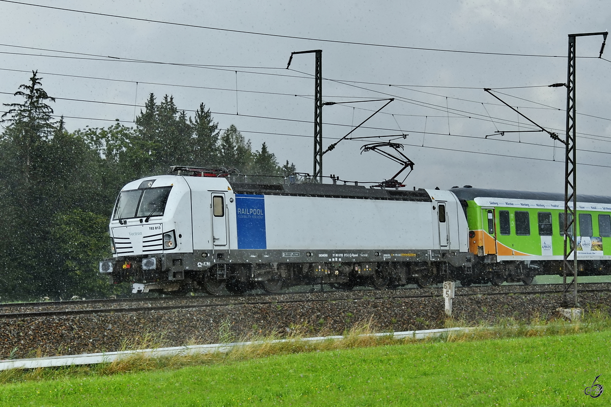 Der einsetzende Regen sorgt für ordentlich Bildrauschen. Railpool 193 813 zieht so ziemlich am Anfang seiner Reise den Alpenland-Sylt-Express in Richtung Nordsee. (bei Fuchsreut, August 2020)
