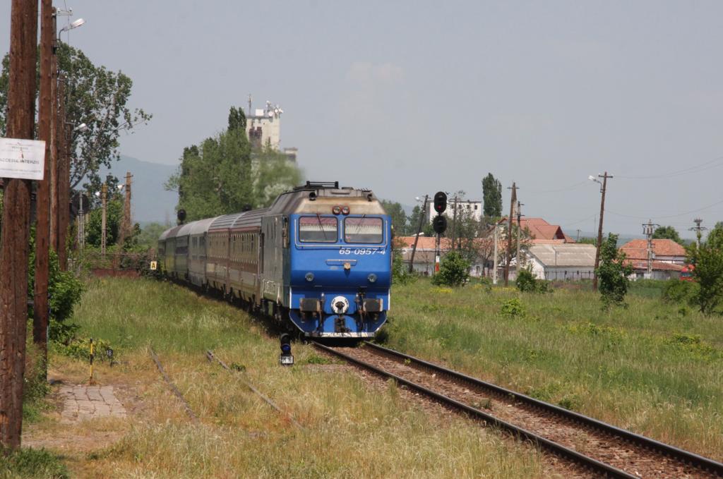 Der einzige hochwertige Express auf der Strecke Sibiu - Brasov ist der internationale Schnellzug  DACIA  347, der täglich Wien mit Bukarest verbindet.
Am 20.5.2015 durchfährt er hier mit Zuglok 65-0957-4 auf dem Weg nach Bukarest den Bahnhof Codlea.