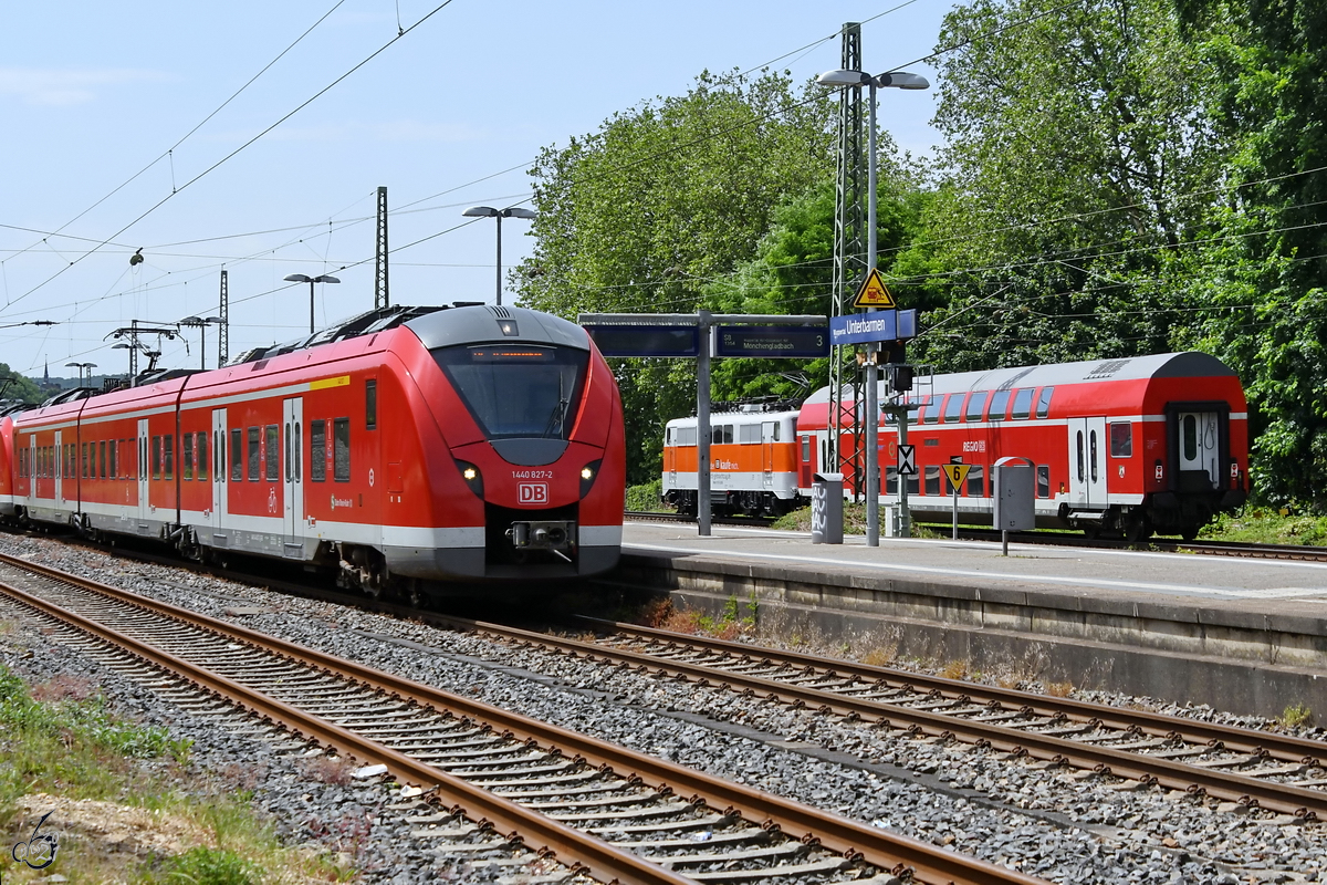 Der Elektrotriebzug 1440 827-2 beim Halt in Wuppertal-Unterbarmen, im Hintergrund die Elektrolokomotive 111 111-1 zieht einen Doppelstockwagen auf dem Weg nach Aachen. (Juni 2021)