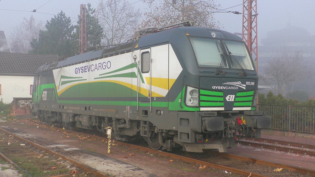 Der ELL Vectron (193 246-6) mit Gysev Aufschrift steht am Morgen des 10.12.2016 im Nebel abgestellt in Dillingen(Saar) neben dem Bahnhofsgebäude am Bahnsteig 1.