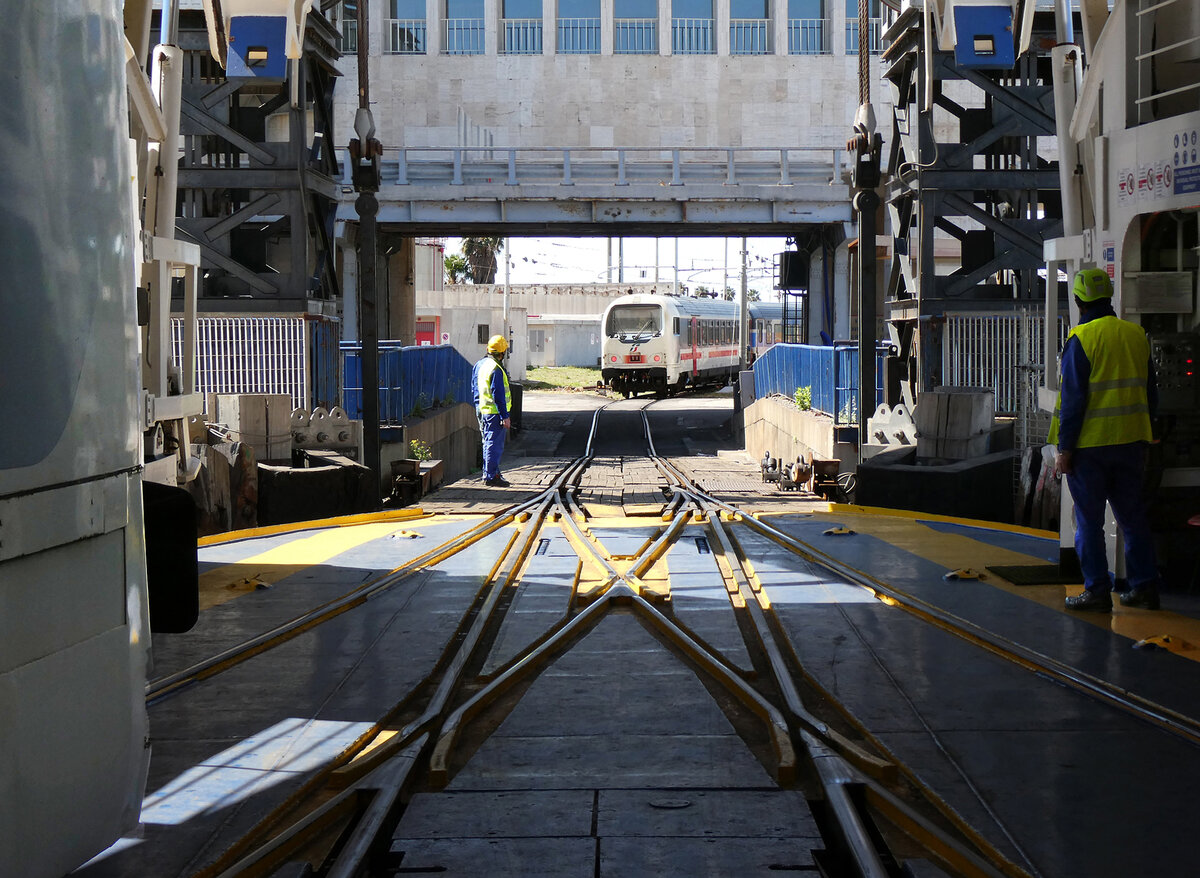 Der erste Teil des IC 728 von Palermo bzw Siracusa ist f�r die Fahrt auf der F�hre von Messina nach Villa S.G. bereits verladen (links), der zweite Teil ist mit dem Steuerwagen voraus im anrollen. Dieses Spektakel findet im Fahrplan im Fr�hling 2026 noch zwei Mal pro Tag/Richtung statt. Messina, 2.5.2026