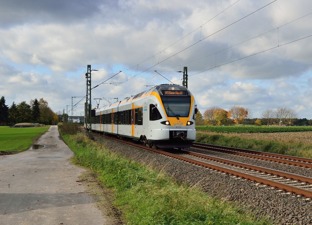 Der ET 7.11 als RE13 aus Venlo kommend, hat vor wenigen Minuten Mnchengladbach Hbf verlassen und ist hier in Korschenbroich  An der Insel  auf seinem Weg nach Hamm/Westfalen zu sehen am Samstagmittag den 9.11.2013