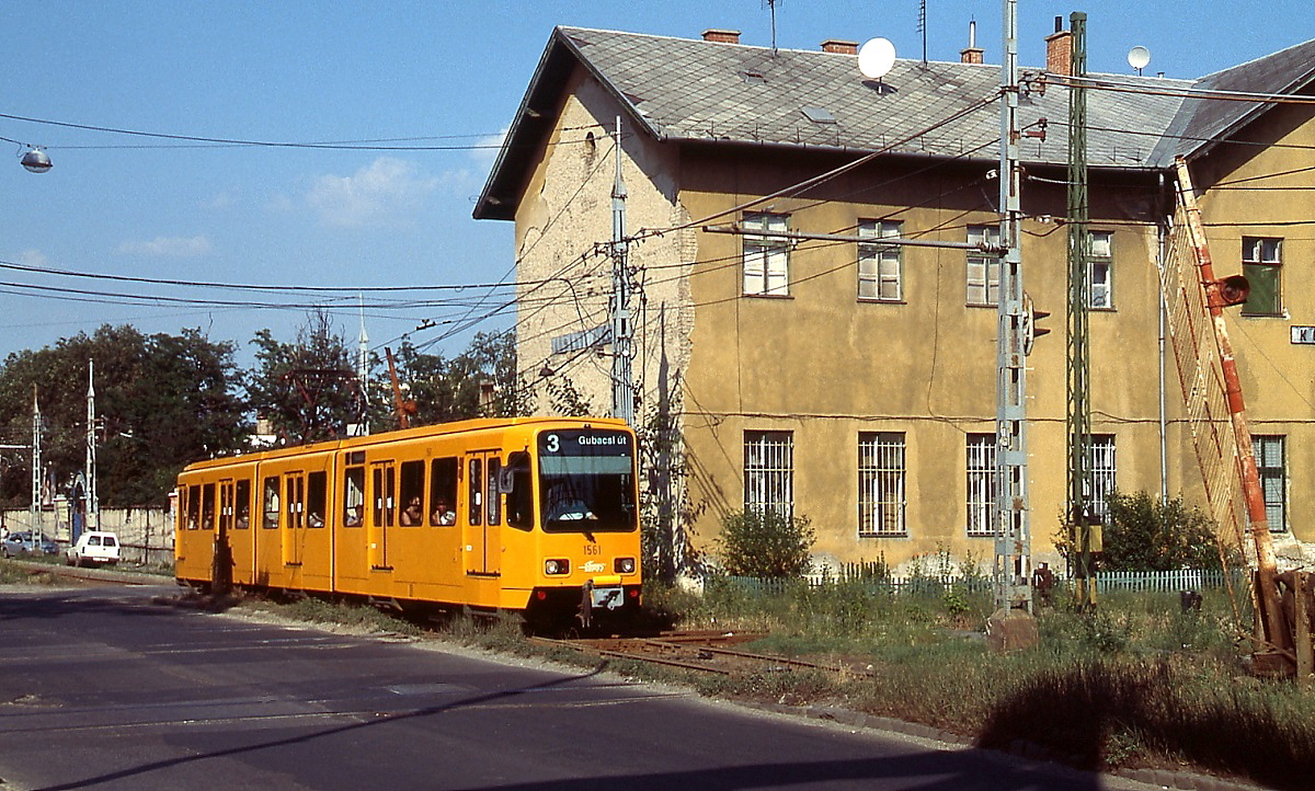 Der ex-Hannoveraner Tw 6127 passiert auf seinem Weg entlang der Hatar ut. im Juli 2003 einen anscheinend nicht mehr benutzten Bahnübergang