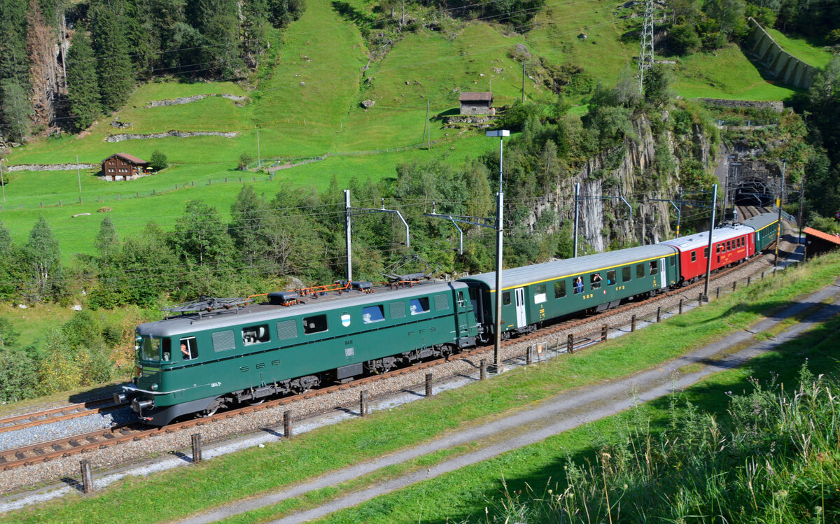 Der Extrazug  Erlebniszug San Gottardo , gezogen von Ae 6/6 11411  Zug , fährt aus dem Wattinger Kehrtunnel bei Wassen die St. Gotthard-Nordrampe hinunter zurück nach Erstfeld. 11.09.2021