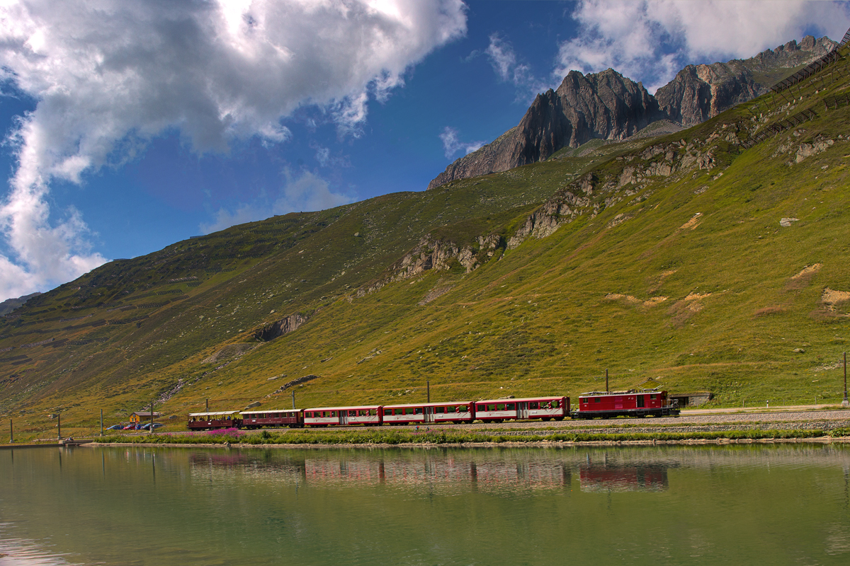 Der FO HGe 4/4 Nr.36 fährt gerade mit dem Swiss Alps Classic Express,der von Zermatt nach St.Moritz unterwegs ist,aus dem Zahnstangenabschnitt am Oberalpsee raus.Bild vom 11.8.2015