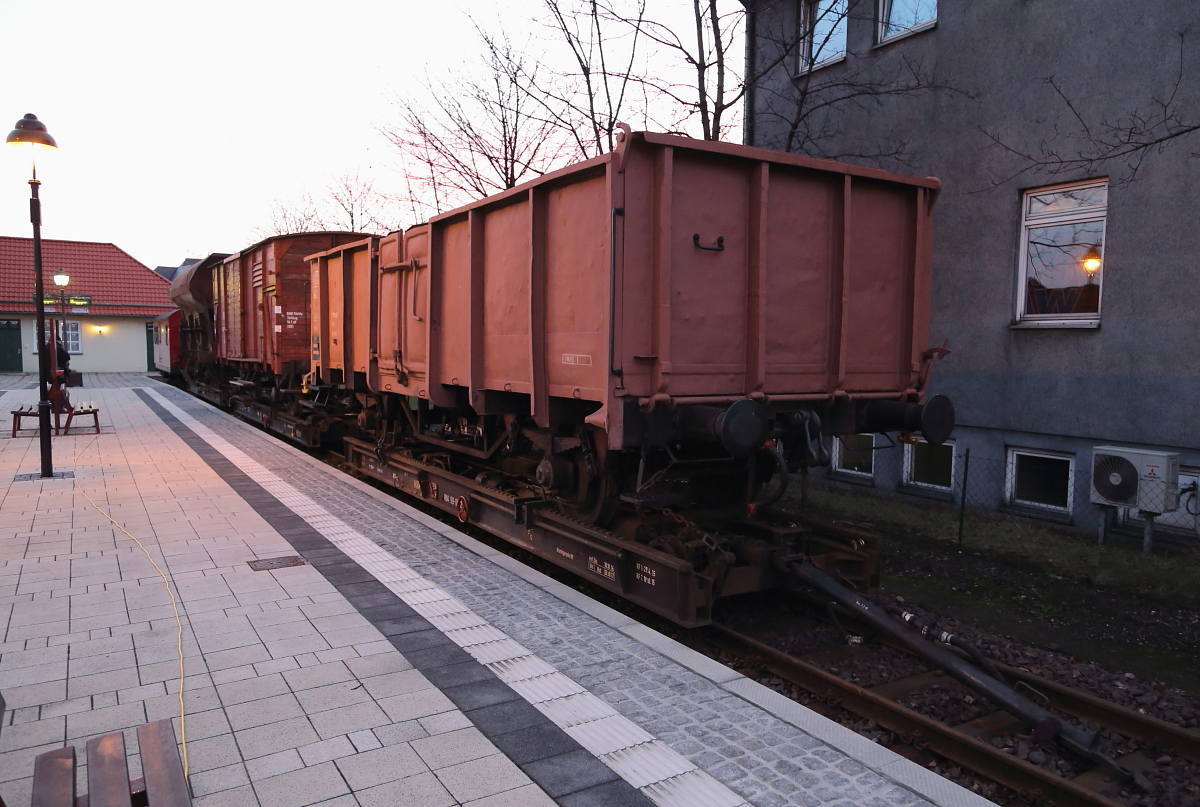 Der Fotogüterzug der IG HSB, bestehend aus 3 Rollwagen mit aufgebockten Regelspur-Güterwagen, sowie einem Begleitwagen, in Erwartung einer Sonderfahrt, am Morgen des 06.02.2016 im Bahnhof Wernigerode.