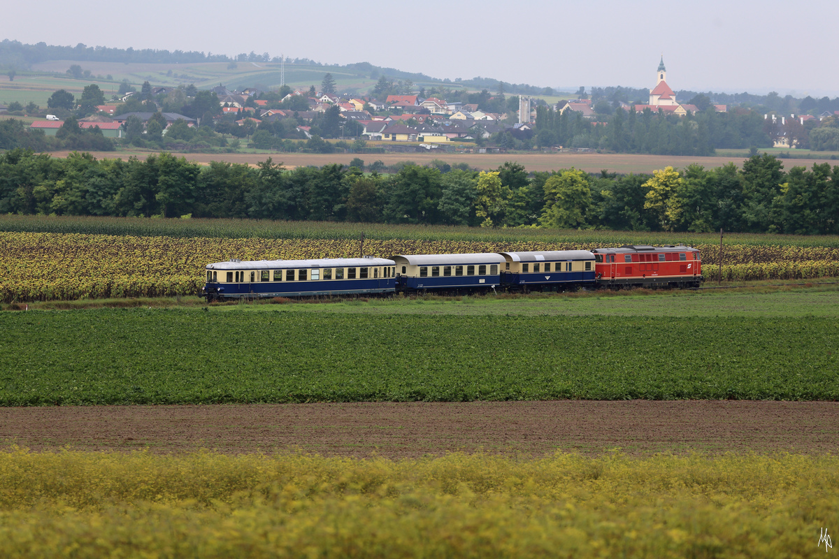 Der Fotozug mit dem 5042.14 an der Spitze und der 2143.070 am Zugende auf der Fahrt nach Obersdorf kurz vor Raggendorf. Im Hintergrund die Kirche von Groß Schweinbarth. (06.09.2020)