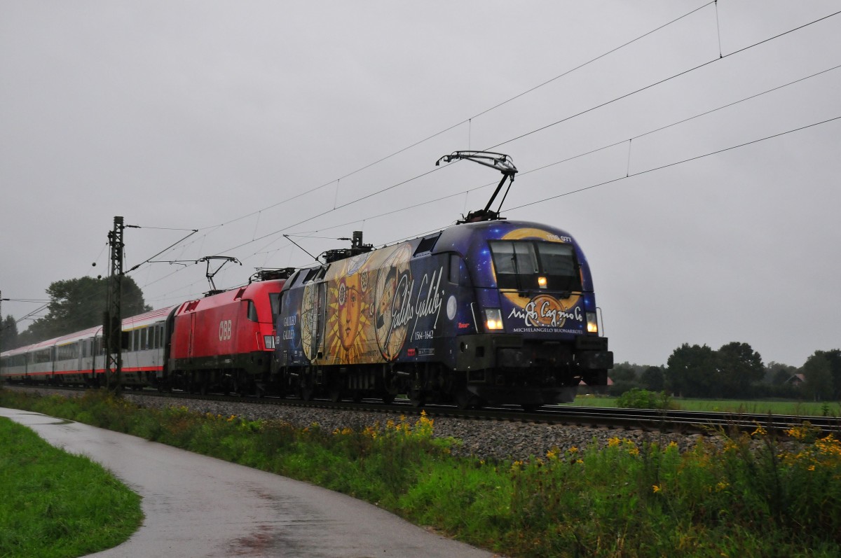 Der Galileo-Michelangelo Taurus 1116 077 der ÖBB mit einer Schwestermaschine bei der Durchfahrt in Übersee am Chiemsee am 31.08.14 bei strömenden Regen (Sommer 2014 ;-)