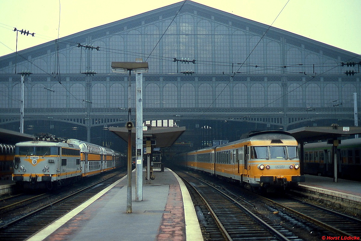 Der Gasturbinenzug T 2042 verlässt im Sommer 1993 den Gare du Nord in Paris, links ein Vorortzug mit einer BB 25000 an der Spitze