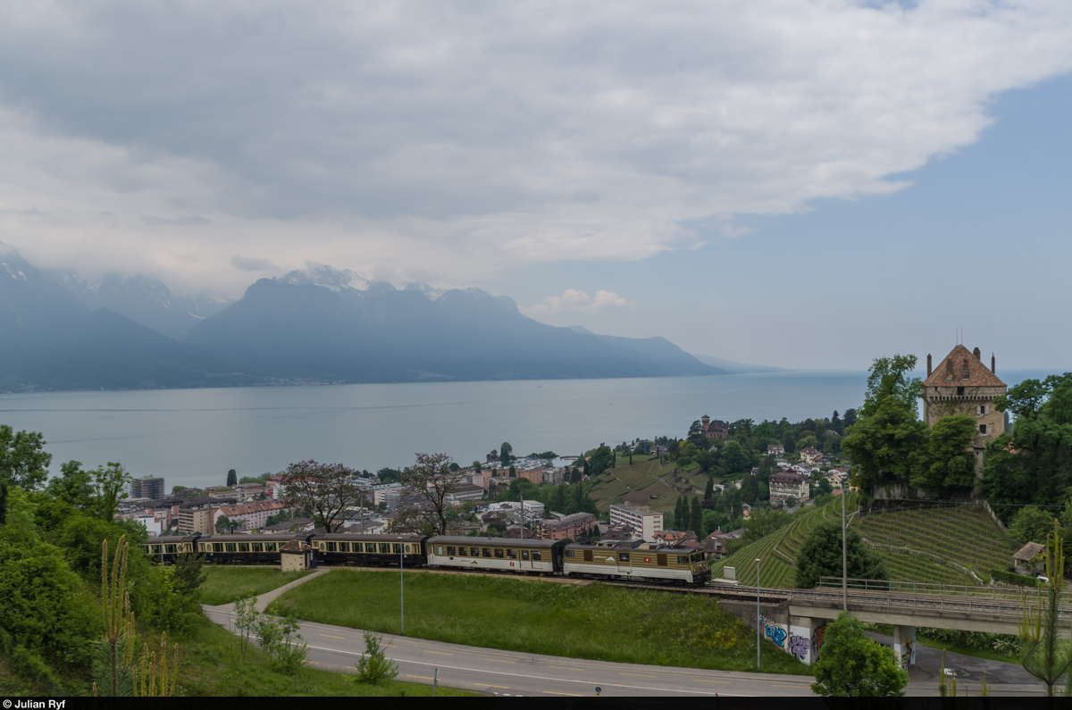 Der von GDe 4/4 6005 gezogene GoldenPass Classic durchfährt am 16. Mai 2015 die Station Châtelard oberhalb von Montreux. Im Hintergrund das Château du Châtelard und der Lac Léman.