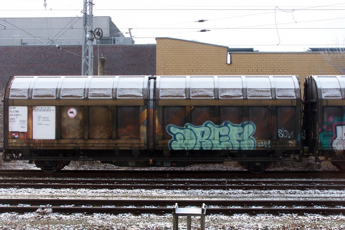 Der gleiche Wagen- eigentlich sind es ja 2 kurzgekuppelte Waggons. Mehr zu ahnen als zu sehen- auf dem rechten Seitenwandsegement der Schriftzug  Nord- ....Waggon stand auf dem anderen Teil. Alles schon abgedeckt durch Graffity und Schmutz. 
Dieser Doppelwagen wurde einmal für die  Nordwaggon  gebaut, hinter der ein bekannter Möbelhersteller steckte (Regal  Billy  usw.). Es dürfte sich dabei um einen Doppelwagen aus der Lieferung vom Werk Niesky aus den 80-ern handeln.  Später gingen sie in den Bestand der TRANSWAGGON über. Aufgenommen am 27.12.14 in Hennigsdorf.
