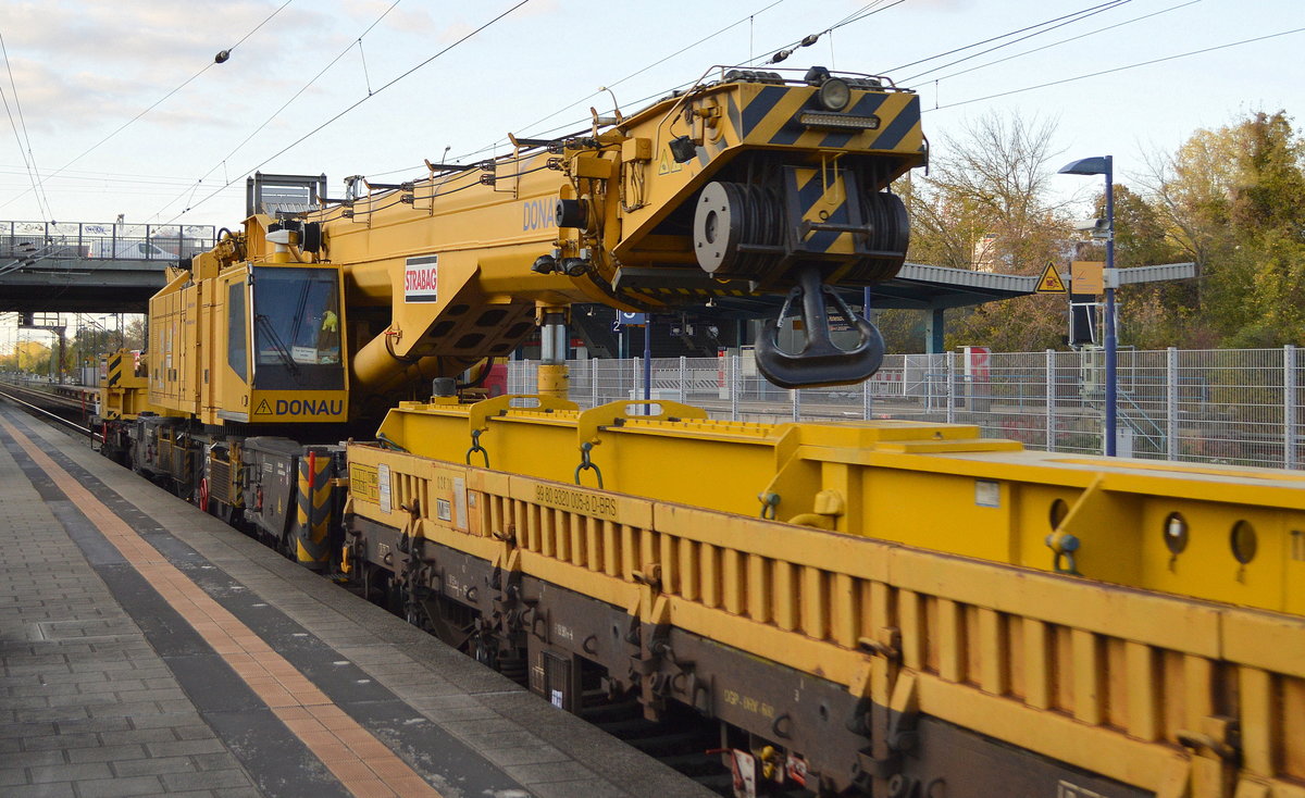 Der Gleisbauschienenkran vom Typ KRC 1200  DONAU  der Fa. STRABAG Rail GmbH (99 80 9419 005-0 D-BRS) hinter dem Schutzwagen (99 80 9320 005-8 D-BRS) am 30.10.19 Durchfahrt Bf. Berlin Hohenschönhausen.